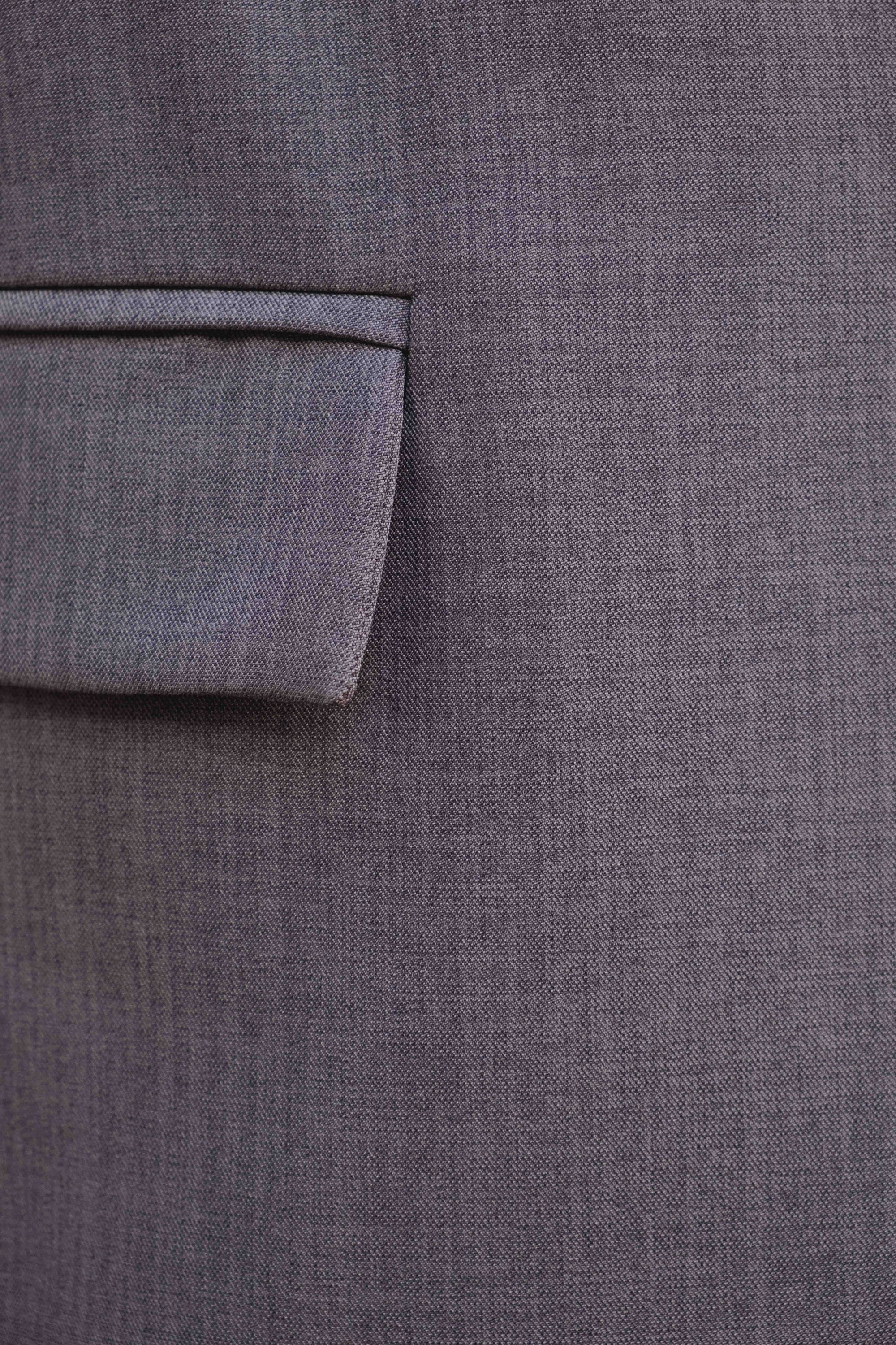 Pantalon Large Taille Haute Gris Élastique Avec Pinces, Gros plan sur le tissu du pantalon gris, montrant la texture et le design soigné avec une poche.