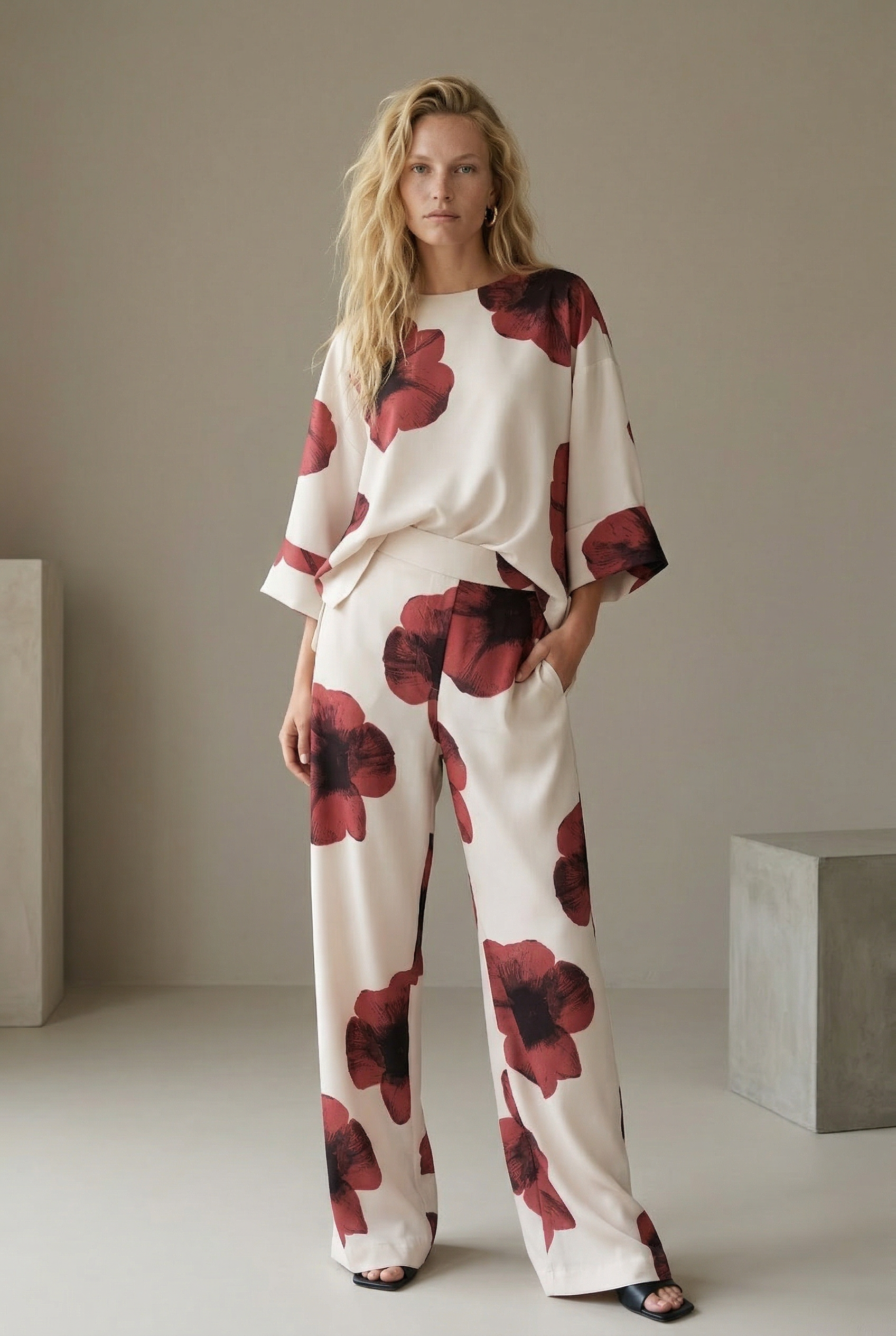 Pantalón de mujer con estampado floral rojo sobre blanco: corte recto moderno, tejido ligero y comodidad óptima.