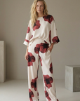 Pantalón de mujer con estampado floral rojo sobre blanco: corte recto moderno, tejido ligero y comodidad óptima.