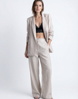 Pantalones fluidos de cintura alta con textura beige para mujer y blazer elegante a juego