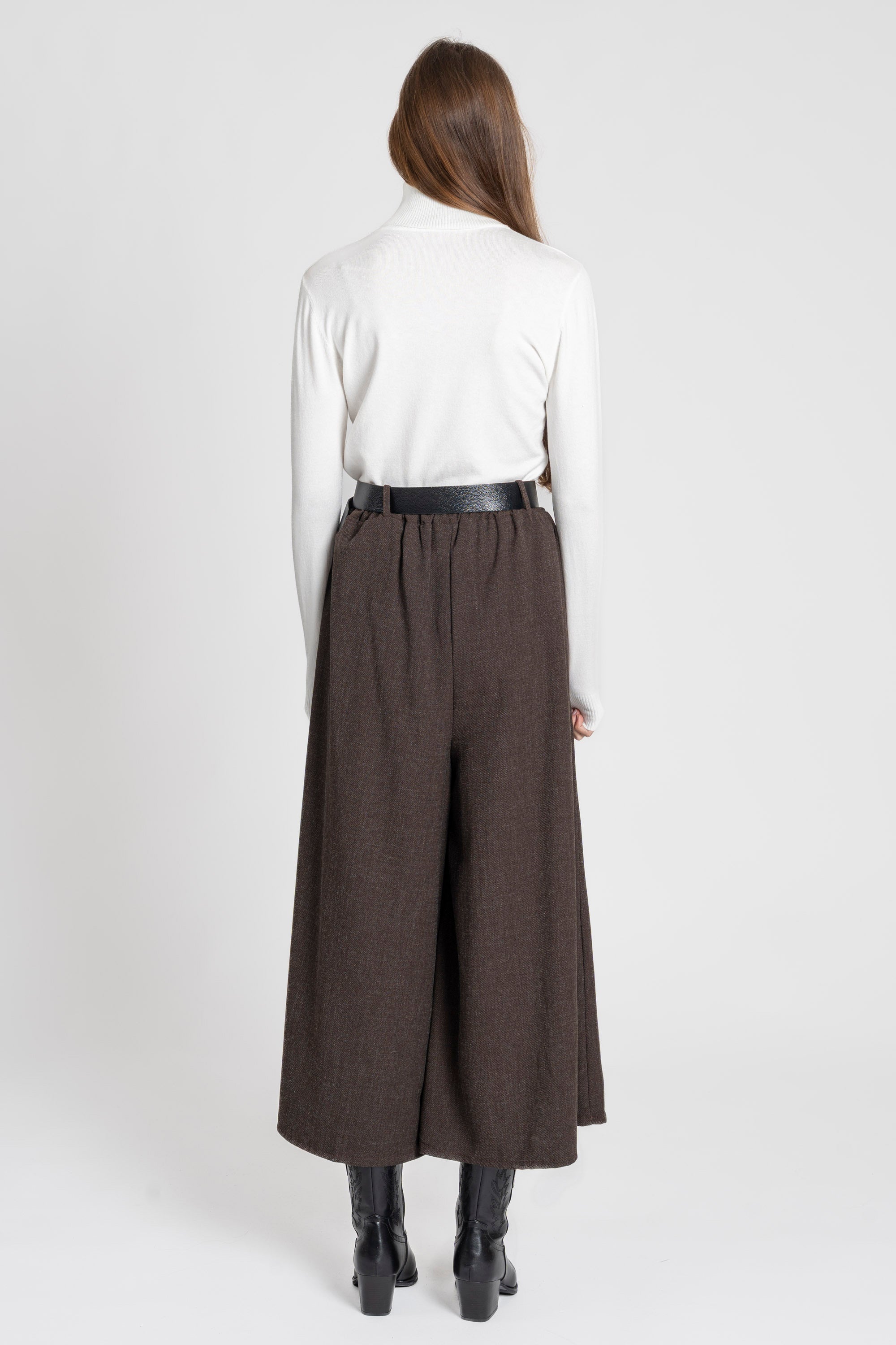 Vue arrière d'une femme portant un pantalon large taille haute femme, avec une ceinture intégrée, associé à un haut blanc.