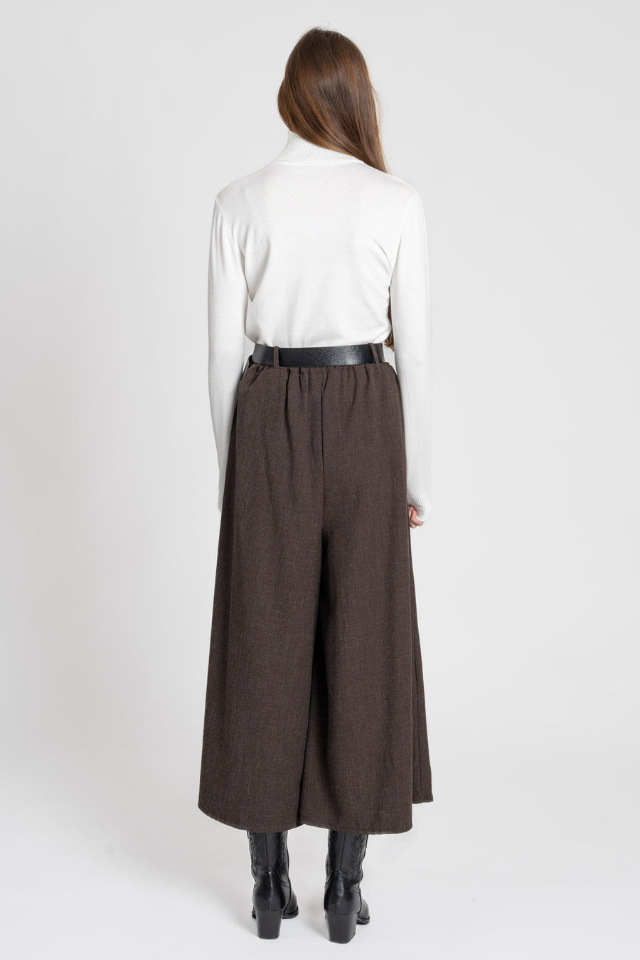 Vue arrière d'une femme portant un pantalon large taille haute femme, avec une ceinture intégrée, associé à un haut blanc.