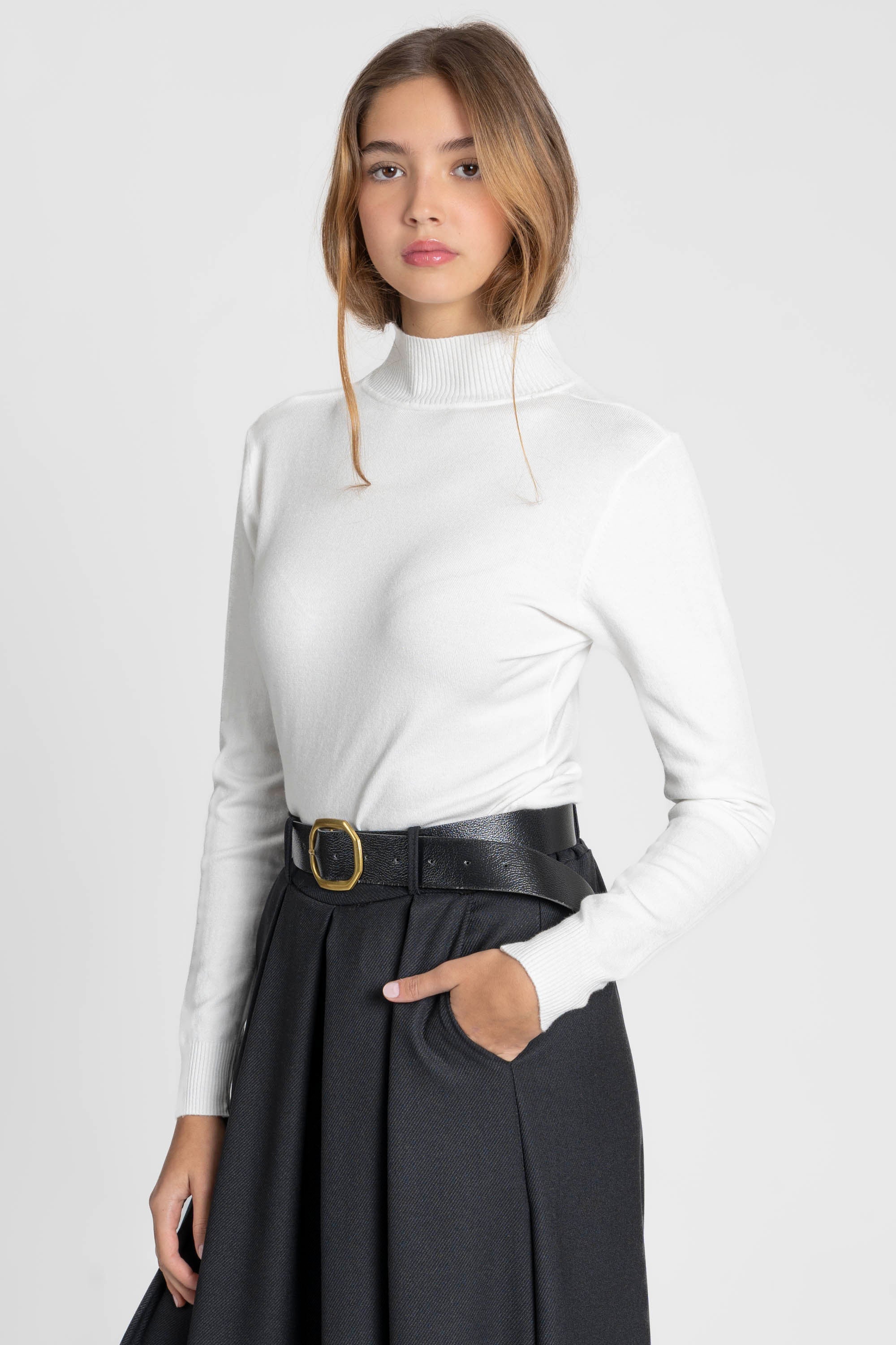 Vue arrière d'une femme en pantalon large taille haute femme noir, portant un haut blanc.