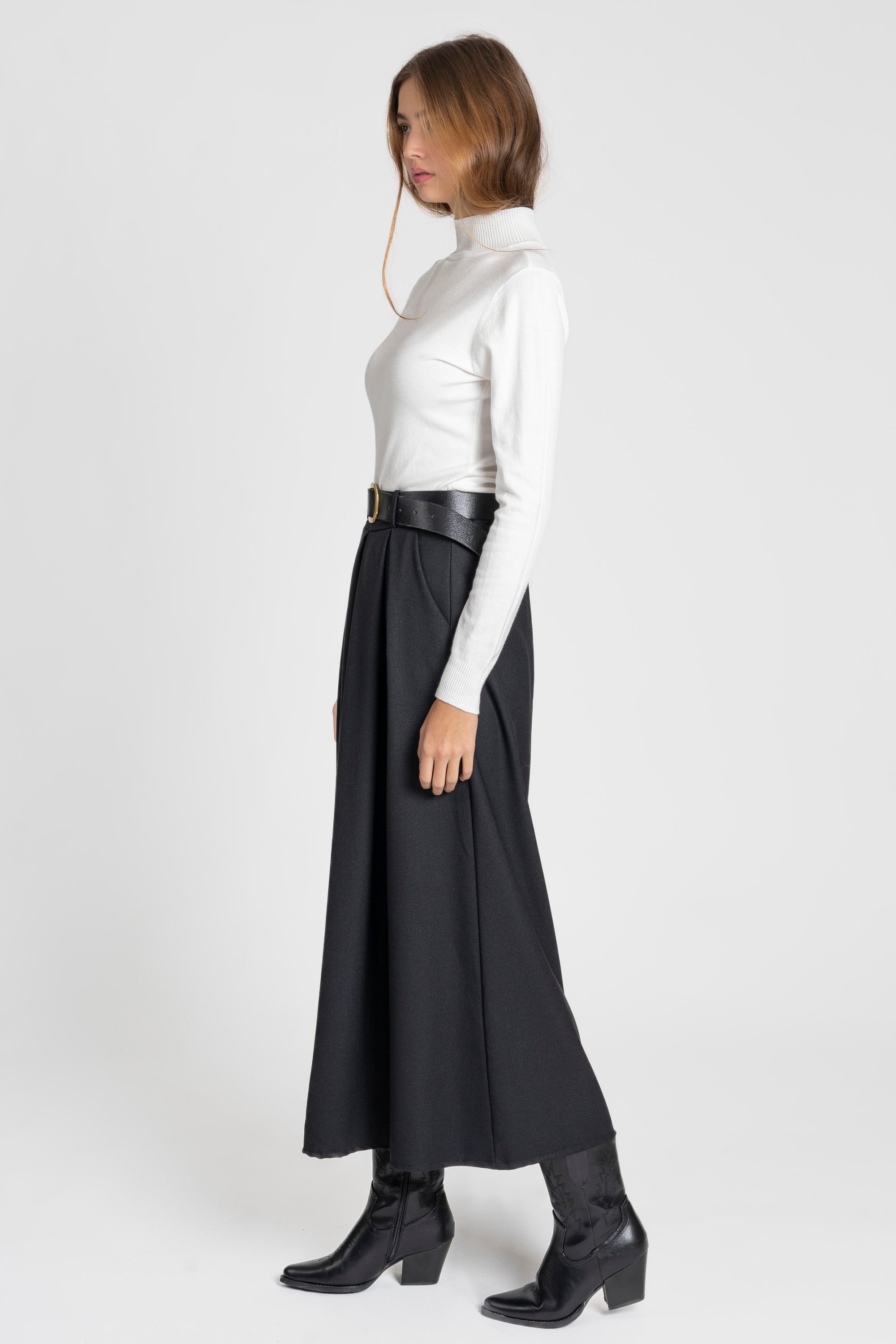Femme en premier plan avec un pantalon large taille haute femme en noir, accentuant son élégance.