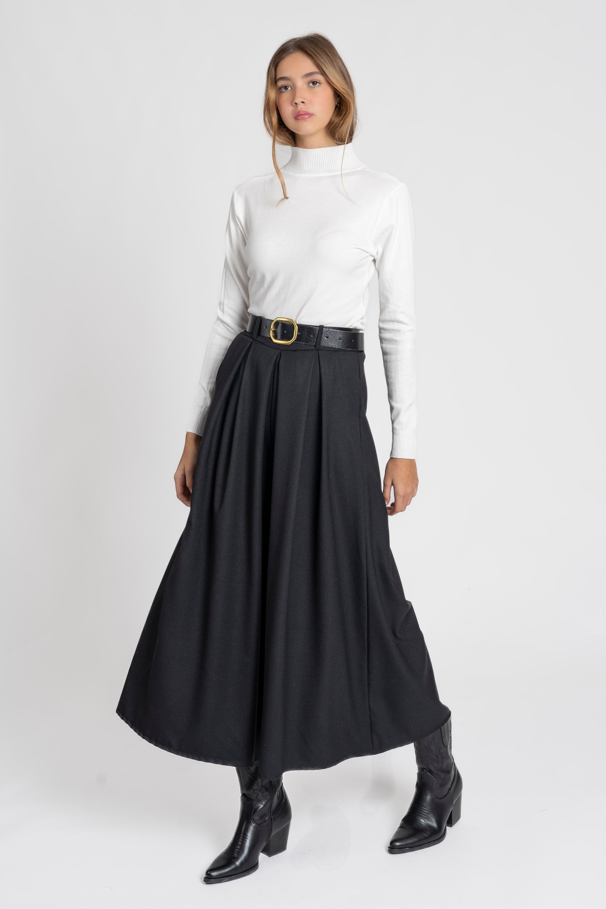 Femme debout en pose naturelle portant un pantalon large taille haute femme en noir, qui souligne sa silhouette.