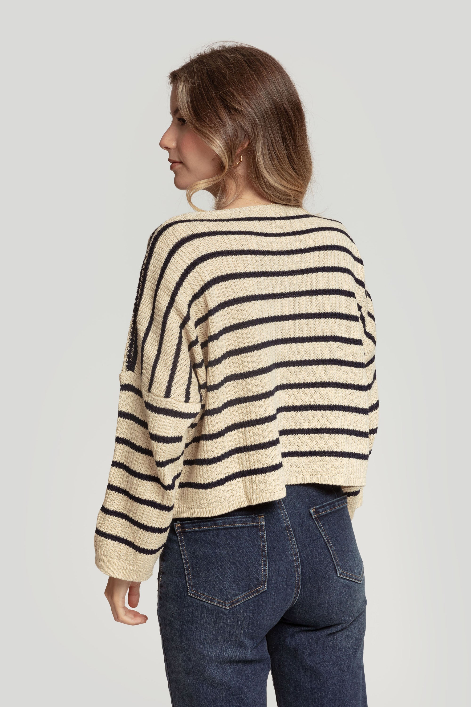 Vue arrière d'un pull court femme en maille torsadée col V style cropped, mettant en avant les rayures bleu marine.