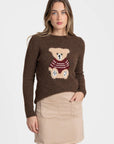 Pull jersey motif ours en mohair laine, modèle marron, porté par une femme avec une jupe beige, parfait pour une tenue décontractée.