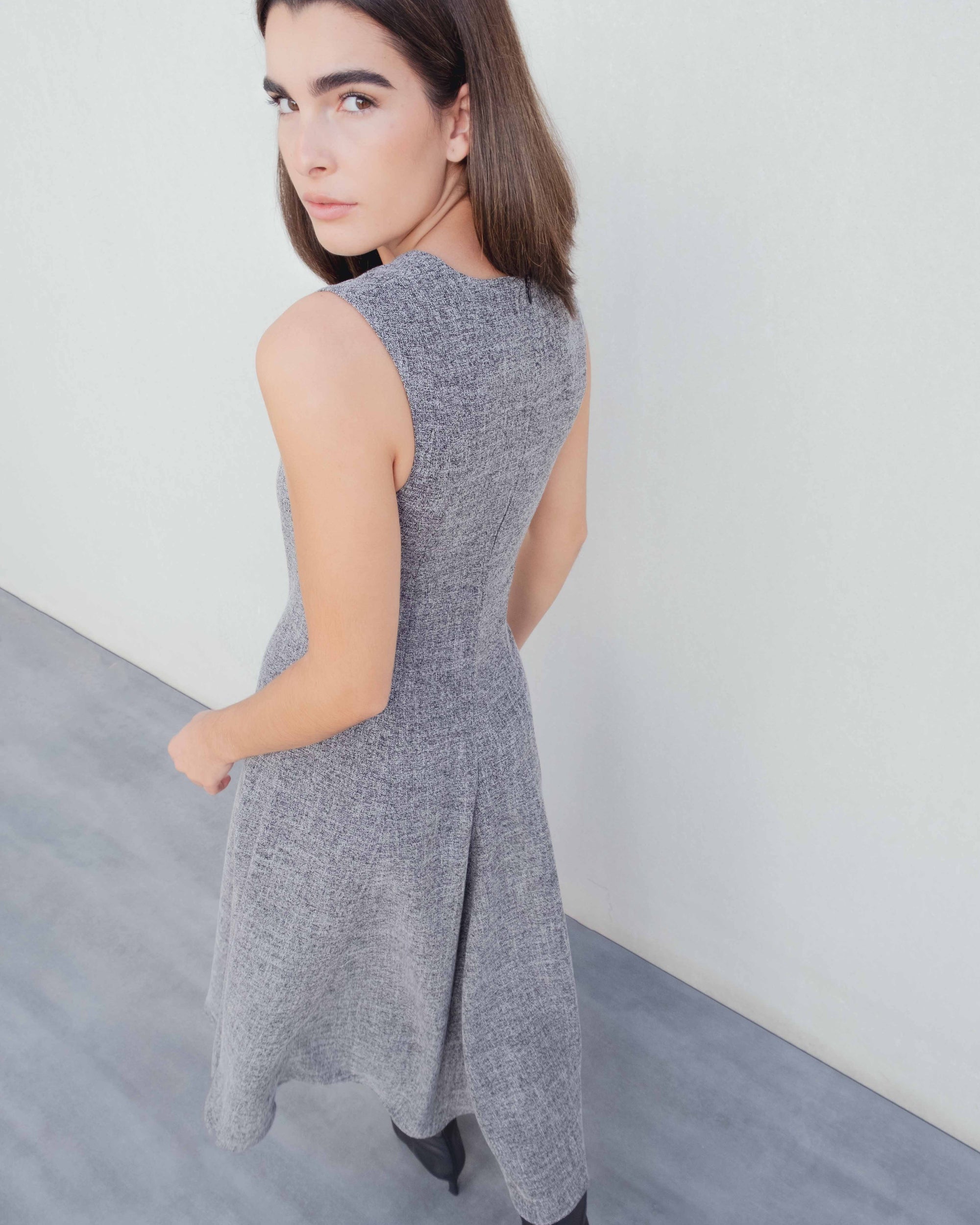 Vue arrière d'une femme dans une Élégance structurée robe midi coupe droite grise polyester viscose, une excellente option pour robe hiver longue.