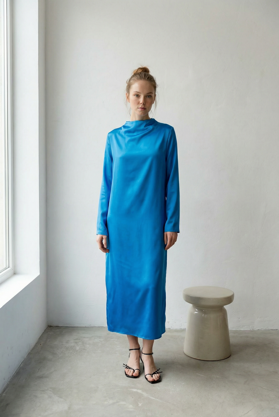 Vestido largo de satén azul eléctrico con cuello alto, mangas largas y abertura en la espalda, elegante y moderno.