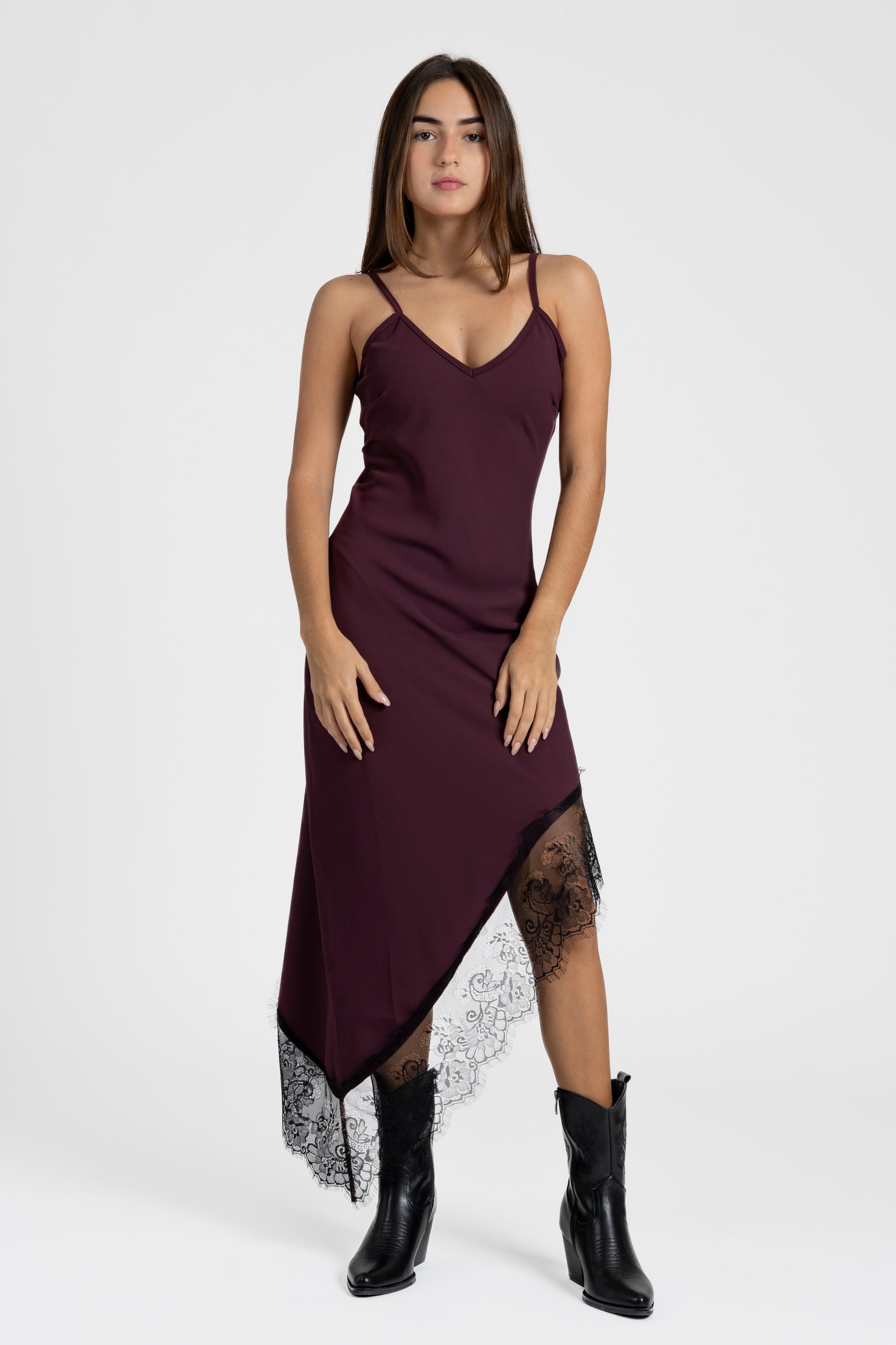 Modèle présentant une robe asymétrique dentelle Bretelles fines Tissu extensible bordeaux, avec des détails en dentelle élégants.