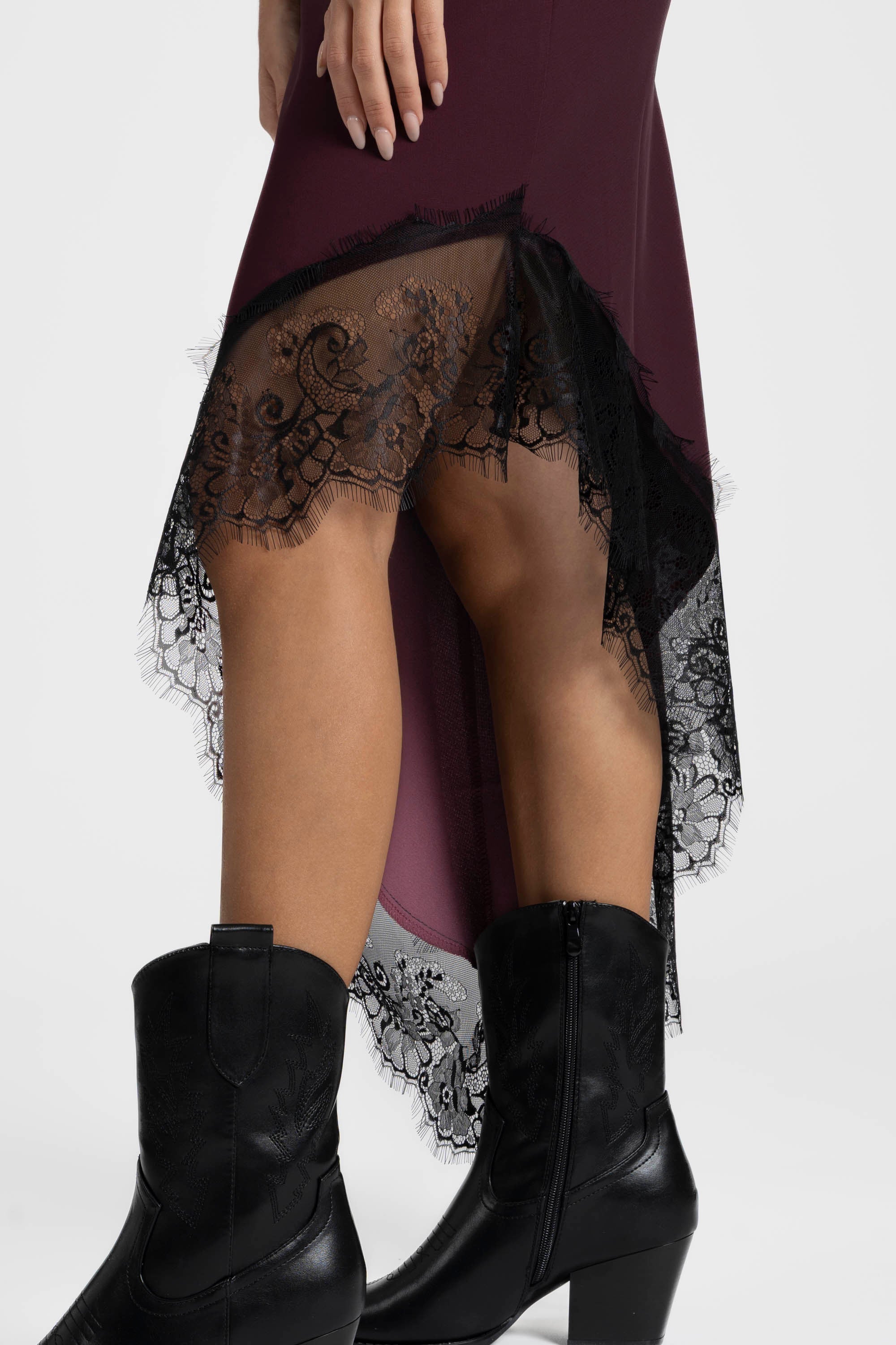 Détail de la robe asymétrique dentelle Bretelles fines Tissu extensible bordeaux, montrant la dentelle raffinée sur le bas.