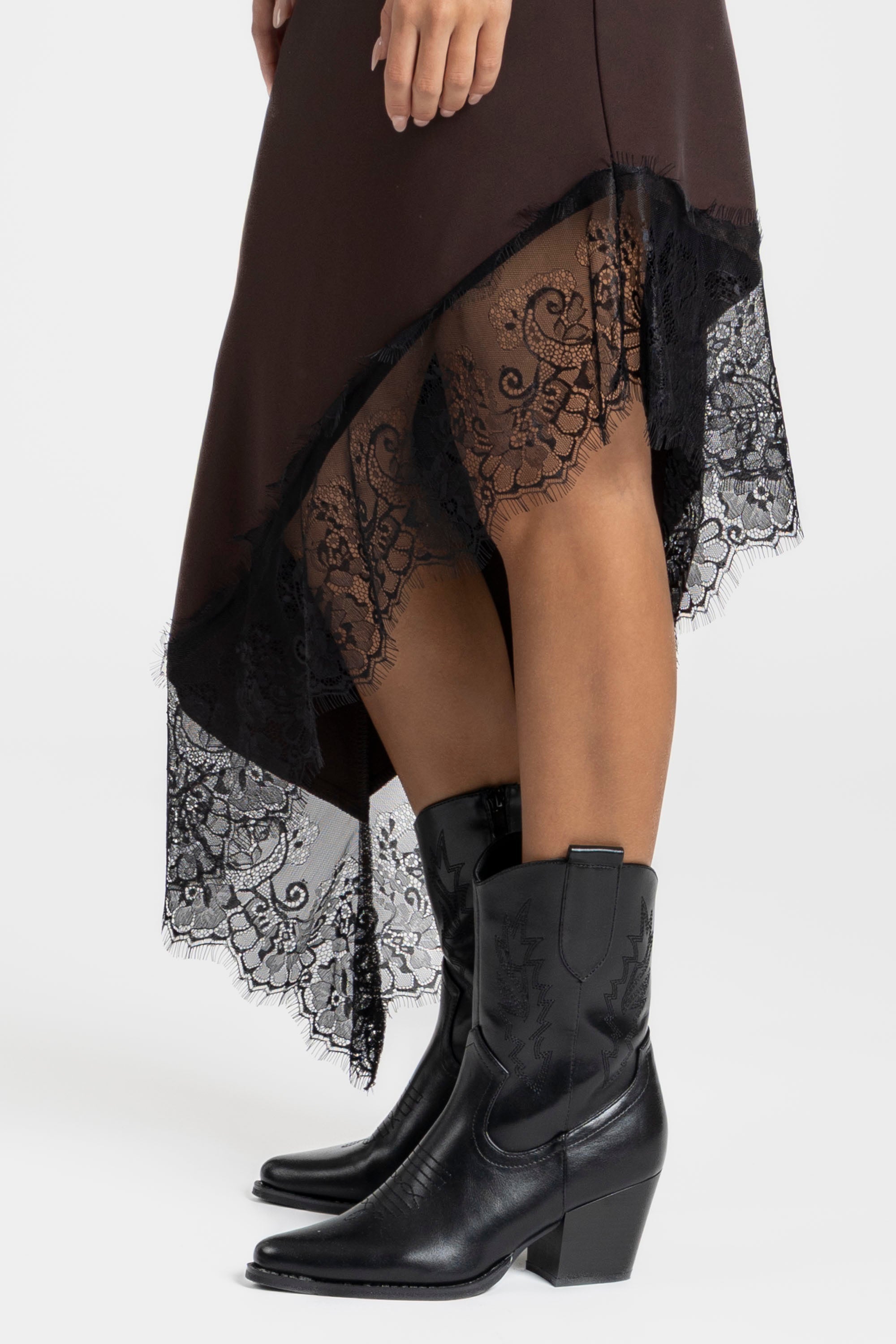 Détail de la robe asymétrique dentelle Bretelles fines Tissu extensible en brun, mettant en avant la dentelle délicate sur le bas.