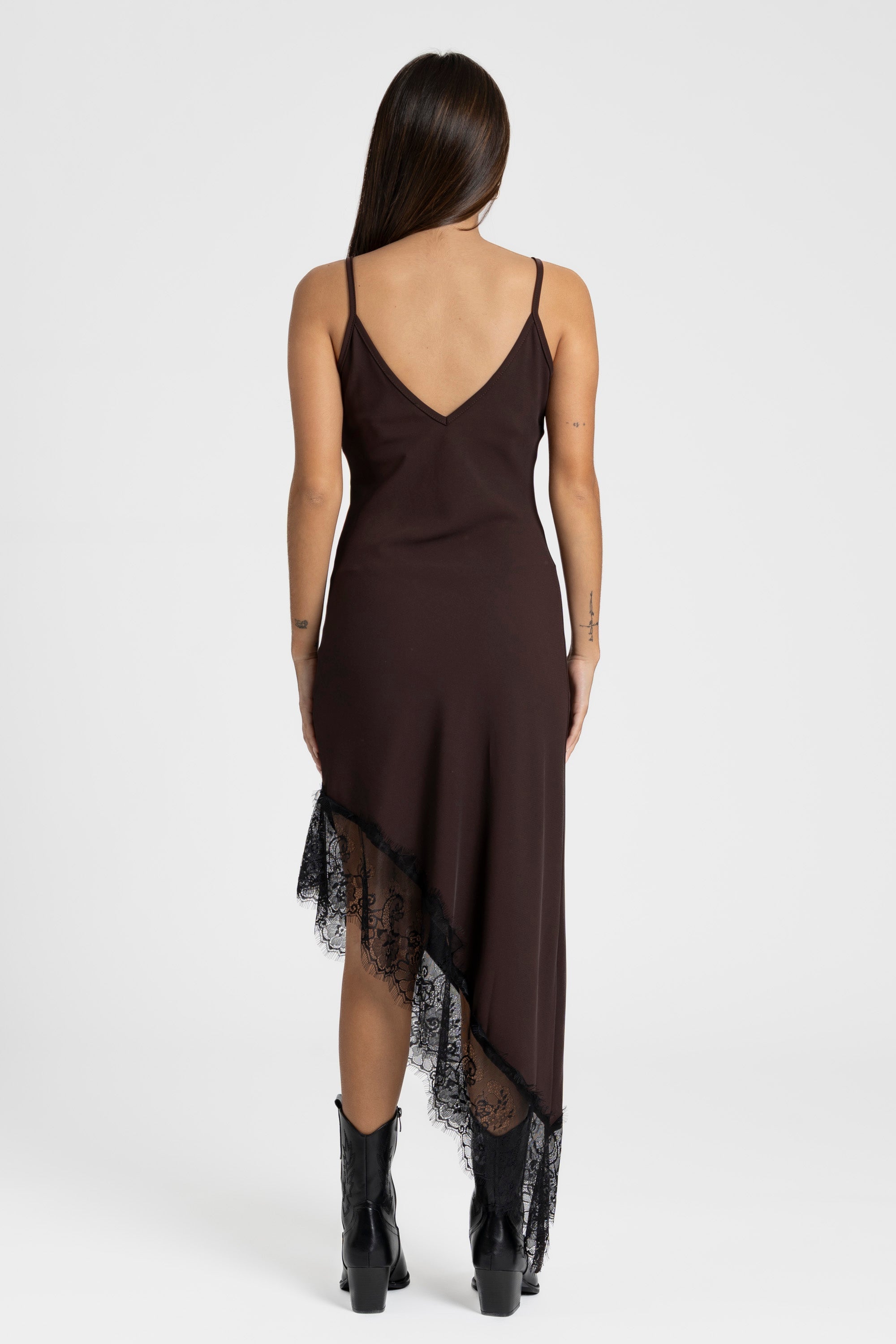 Vue arrière d'une femme dans une robe asymétrique dentelle Bretelles fines Tissu extensible en brun, montrant une finition soignée.