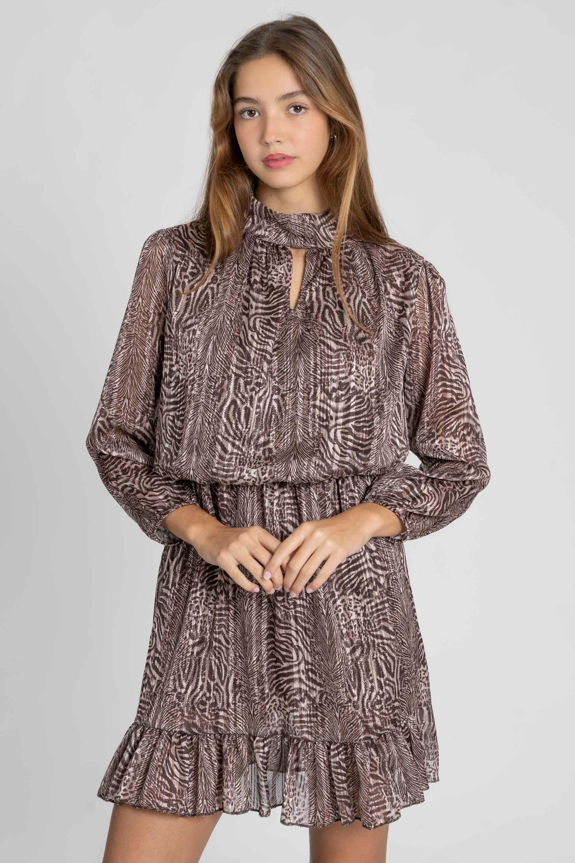 Portrait d'une femme en robe courte fluide animal print, avec un col rond et lien, parfaite pour un look chic.