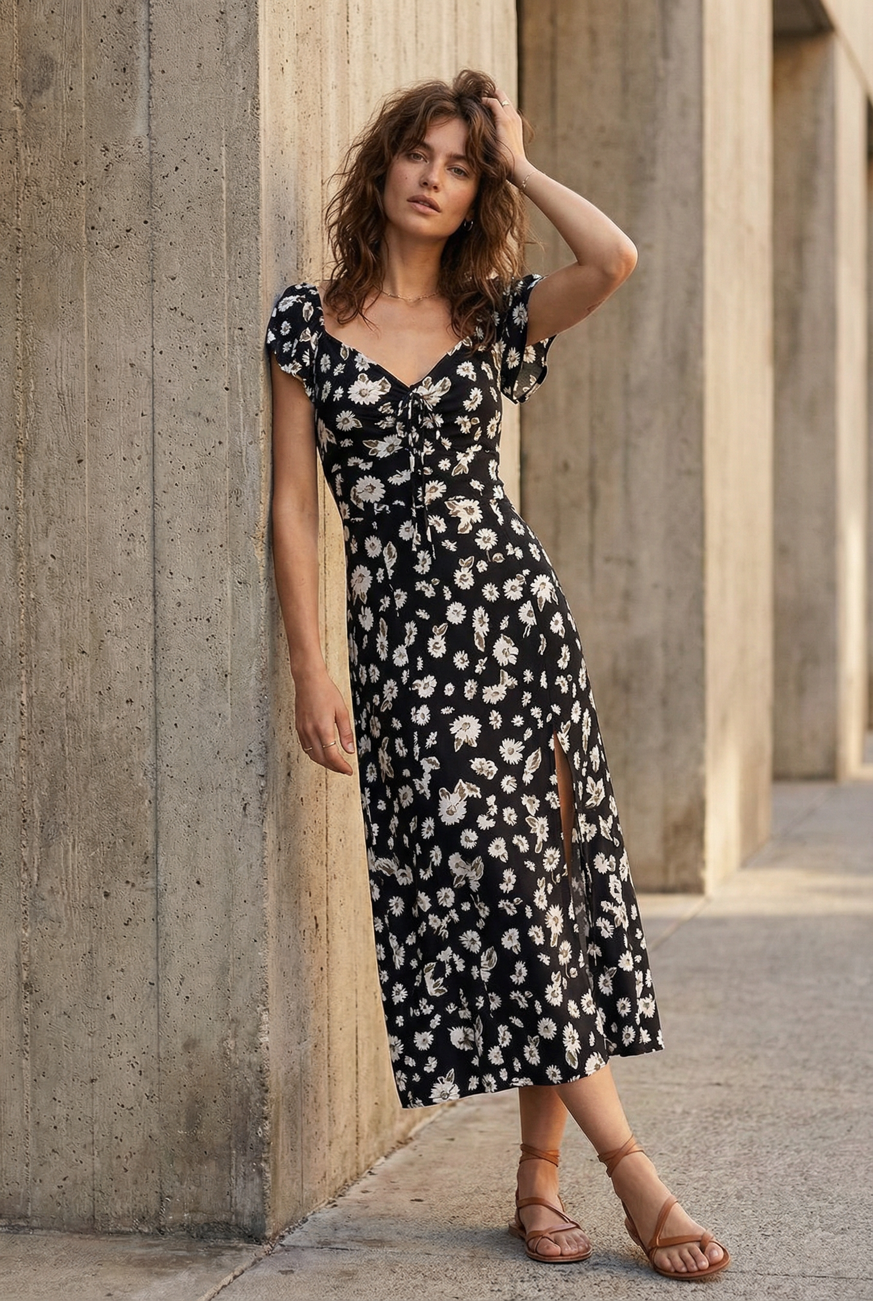 Modèle portant une robe longue noire à imprimé floral fendue sur le côté élégante, mettant en valeur le style romantique de la robe avec fente latérale.