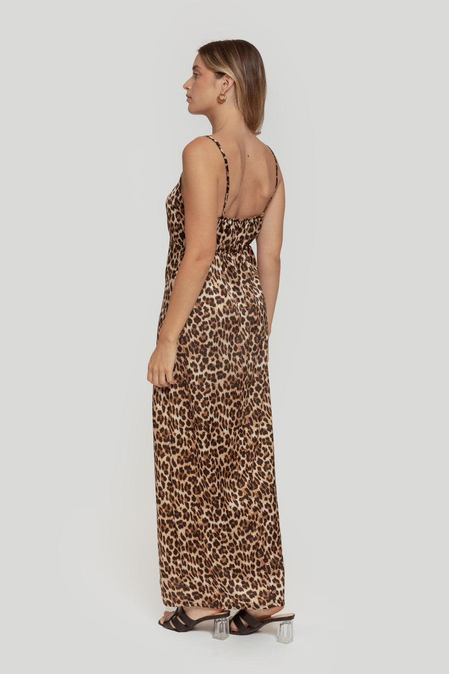 Femme vue de dos en robe longue satinée léopard avec un design élégant, mettant en valeur la coupe droite et le confort.