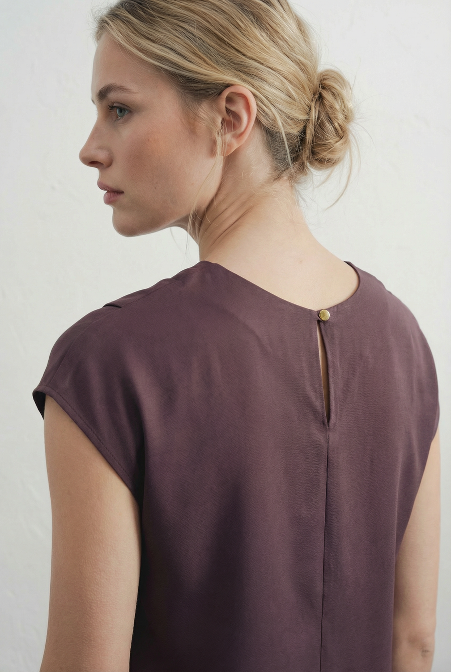 Femme de dos montrant la fermeture discrète de la robe midi marron élégante à col rond, une pièce essentielle pour une garde-robe féminine.