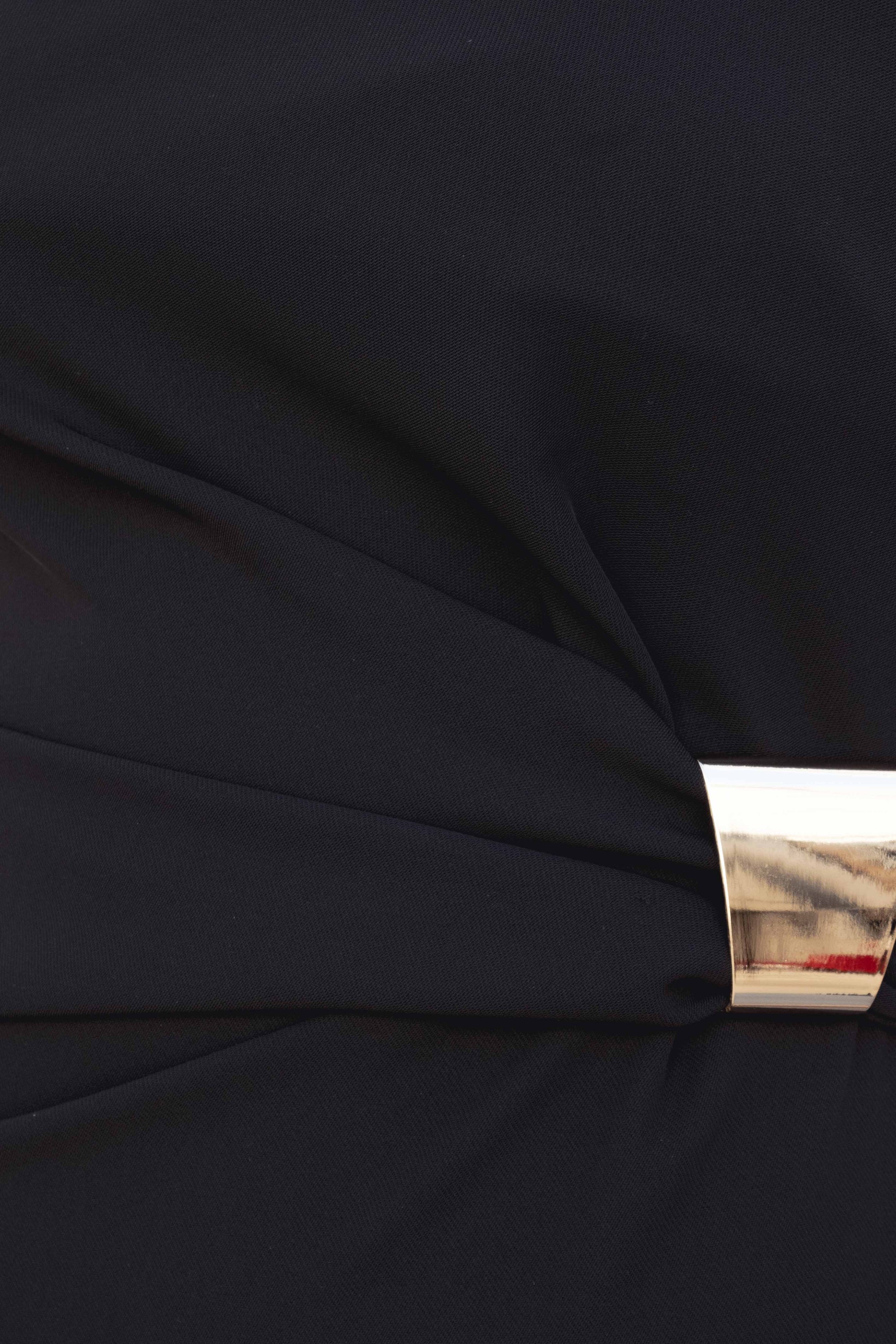 Détail de l'applique dorée sur la robe midi noire élégante, soulignant la texture et la qualité du tissu.