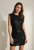 Femme affichant une robe mini noire pailletée, parfaite pour un look festif et sophistiqué lors de cocktails.