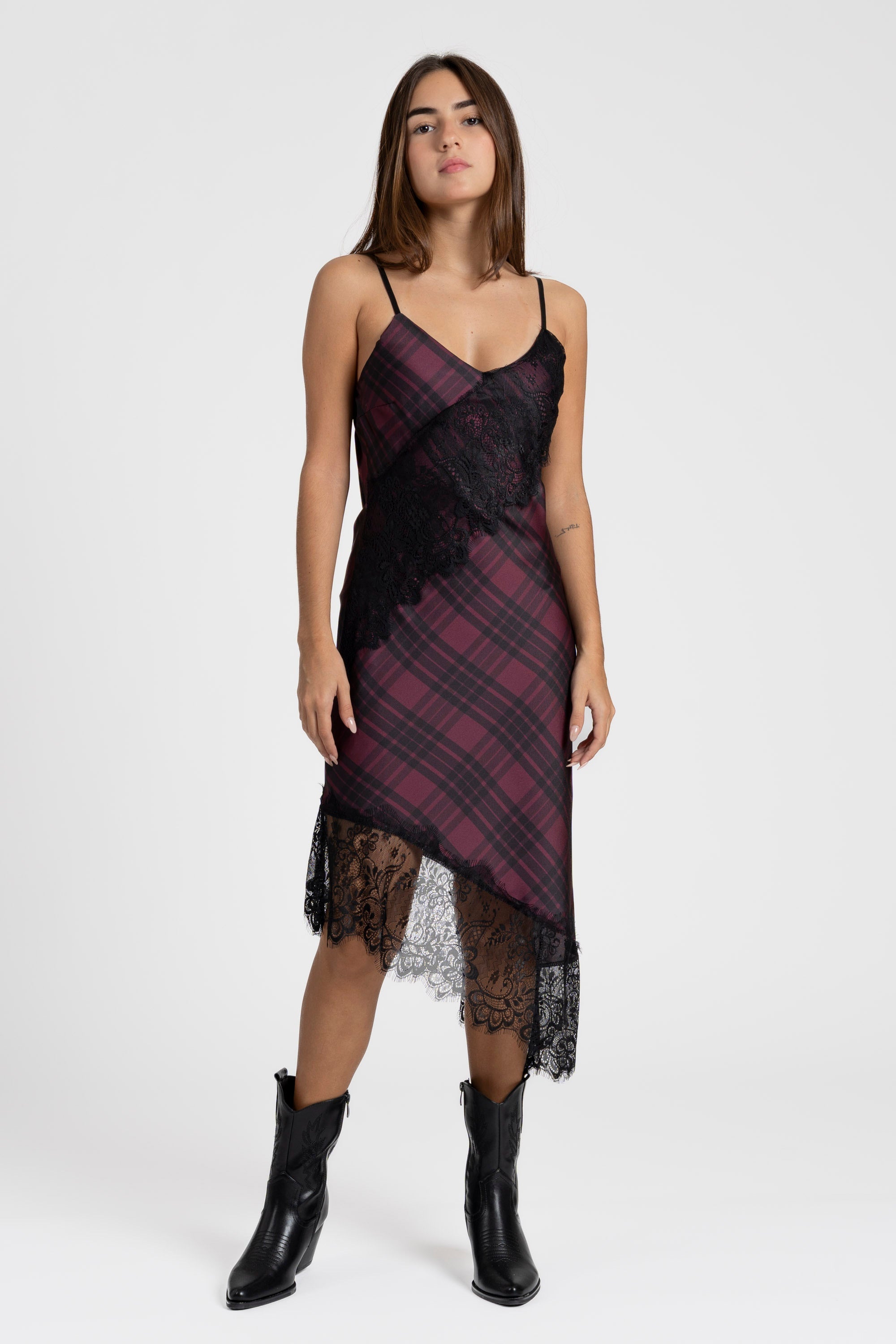 Femme portant la robe satin asymétrique en bordeaux avec un décolleté en V et dentelle raffinée, en style décontracté.