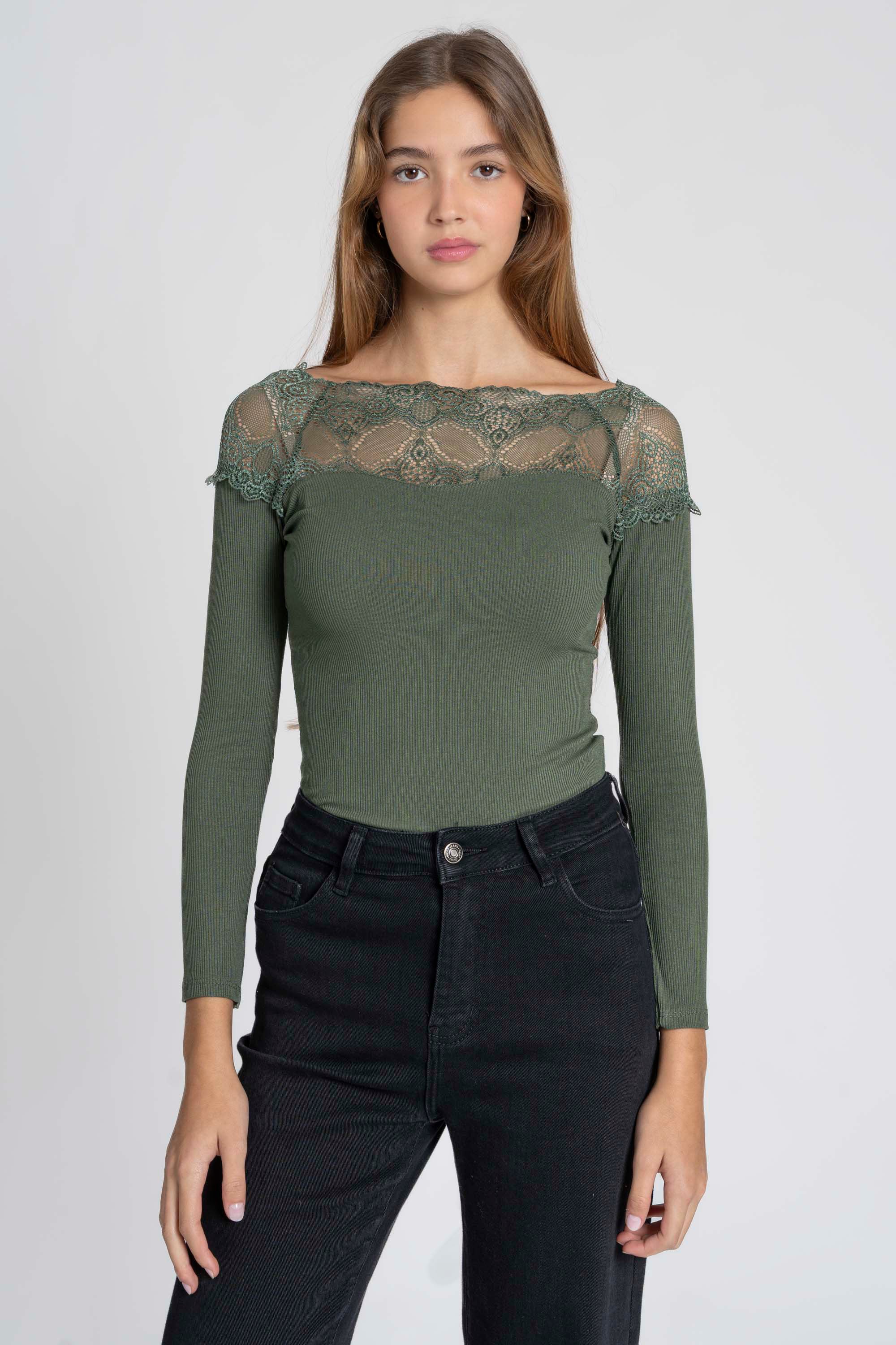 Femme debout dans un T-shirt dentelle Manches longues vert, offrant une allure élégante et sophistiquée.