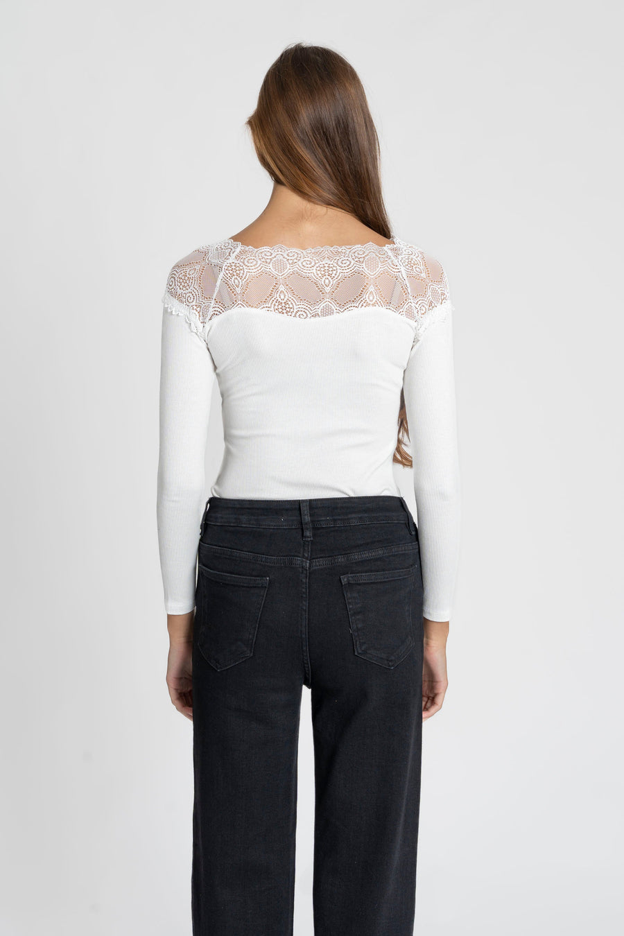 Femme de dos dans un T-shirt dentelle Manches longues blanc, mettant en valeur le design élégant de la dentelle.