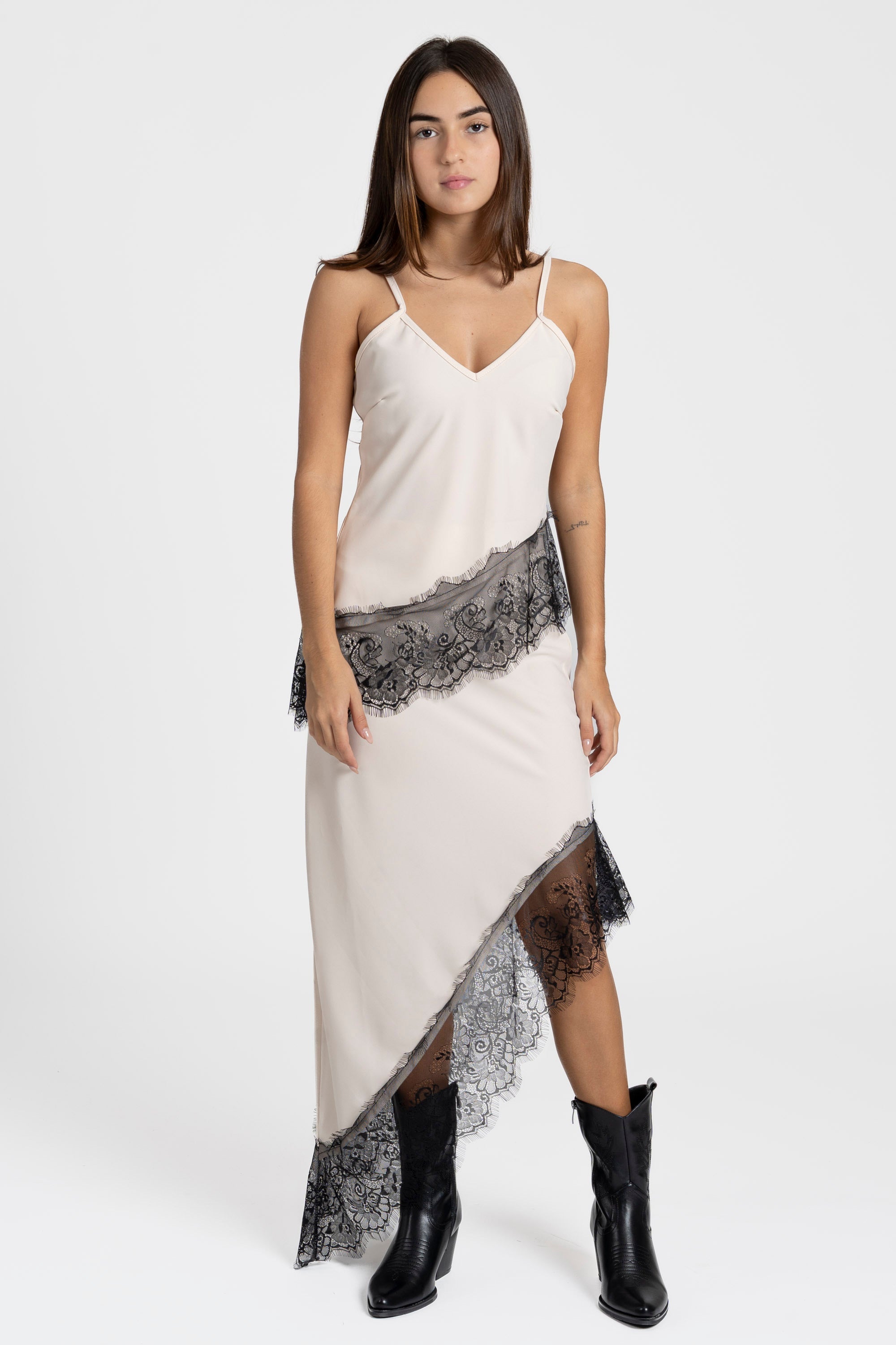 Top dentelle beige avec bretelles fines et décolleté en V, porté par une modèle, style chic.