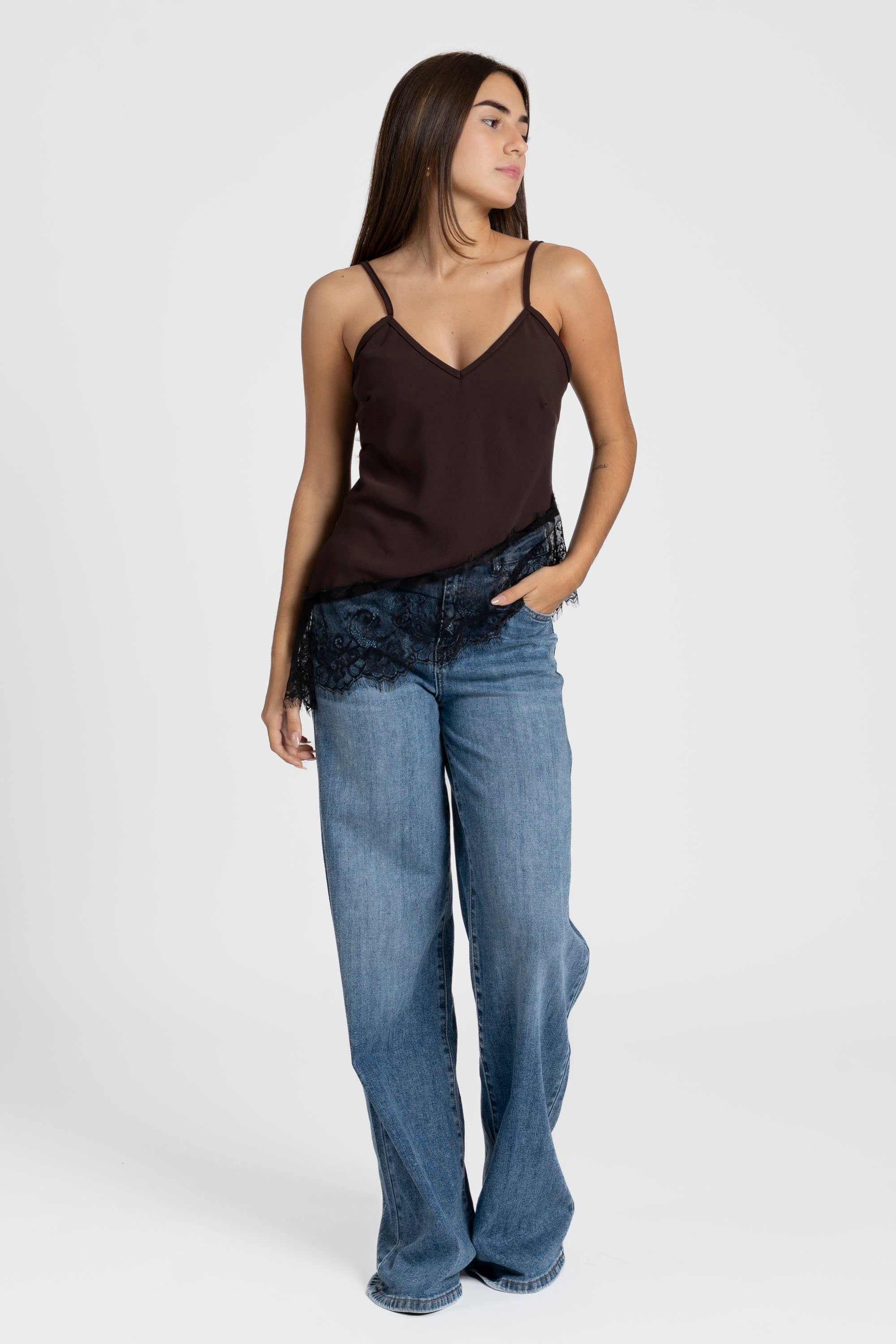 Top dentelle marron porté avec un jean ample, style détendu et élégant.