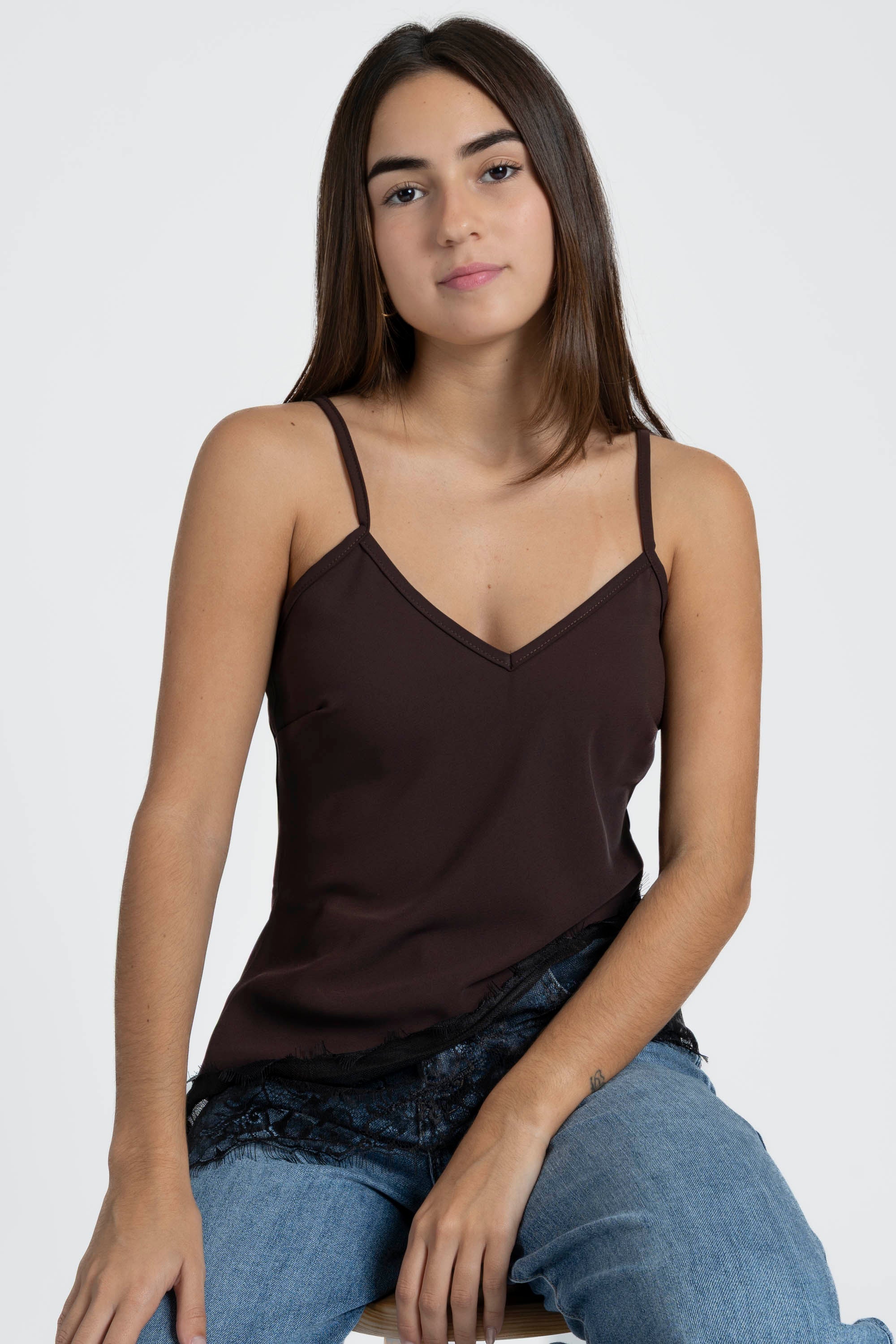 Modèle affichant le top dentelle marron, style casual-chic avec un jean.