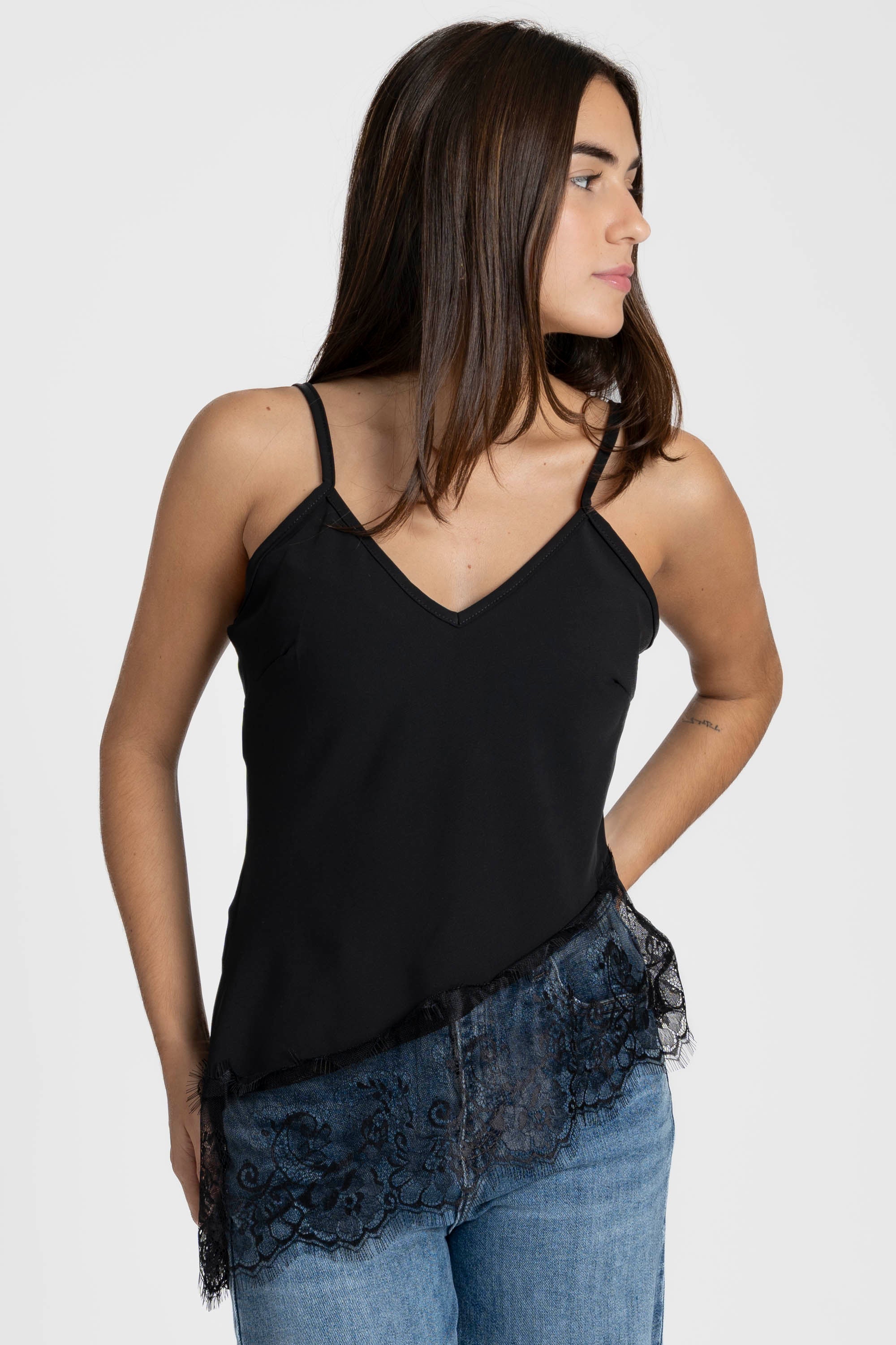 Profil d'une modèle portant le top dentelle noir avec bretelles fines, mettant en avant la dentelle.