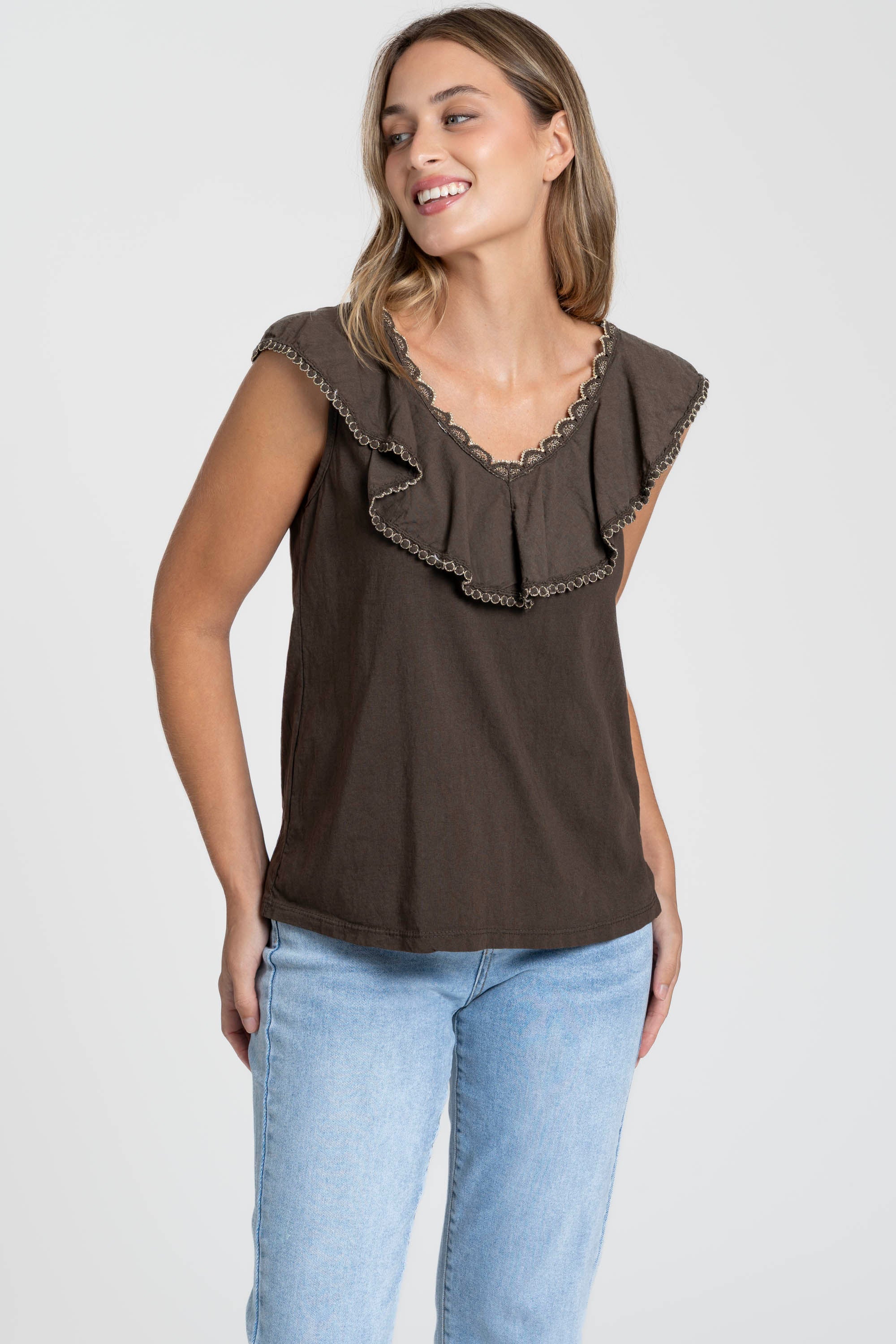 Femme portant le Top coton brodé avec volants, col V sans manches en couleur marron, idéal pour un look décontracté ou élégant.