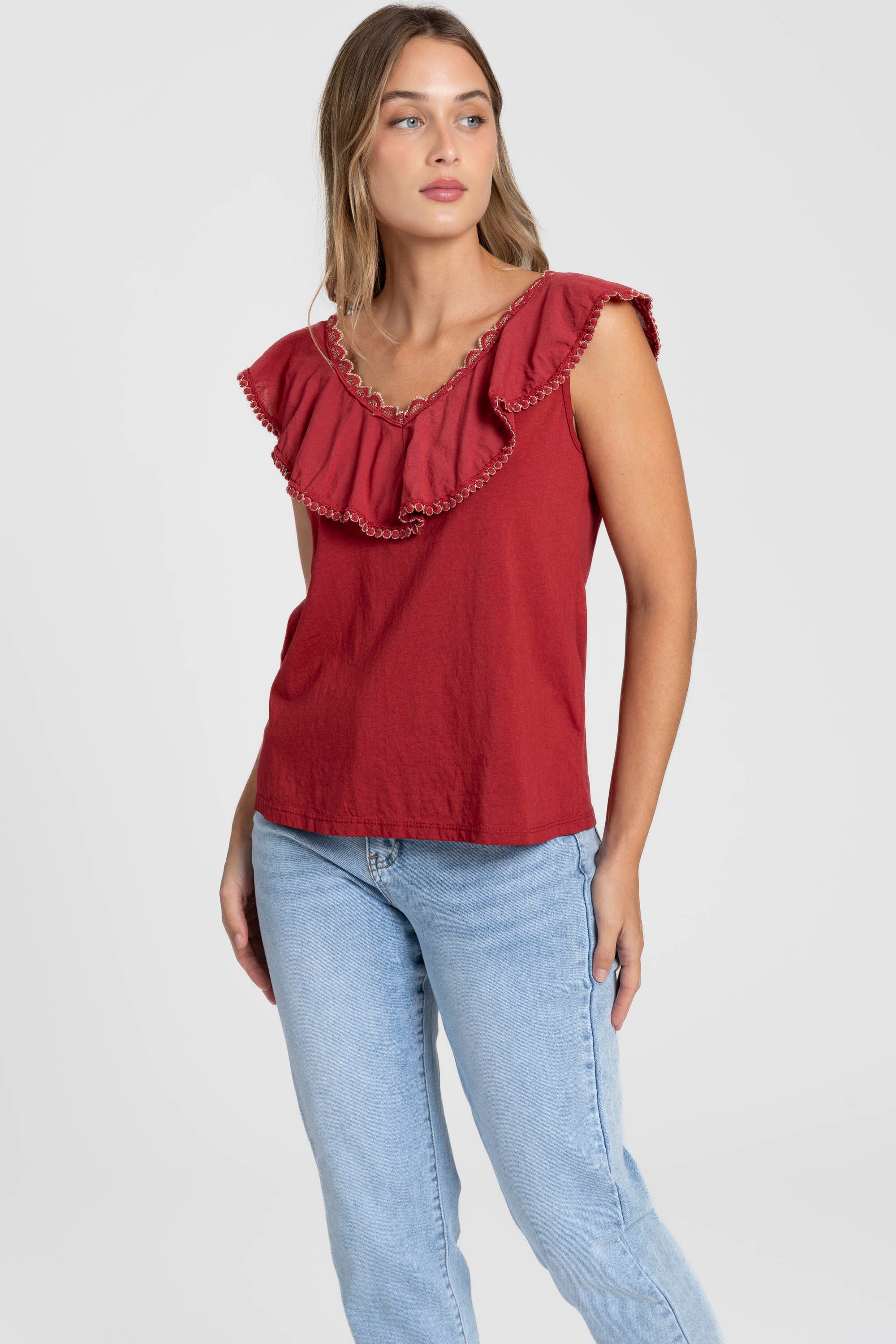 Femme portant le Top coton brodé volants femme col V sans manches en rouge, parfait pour un look estival.