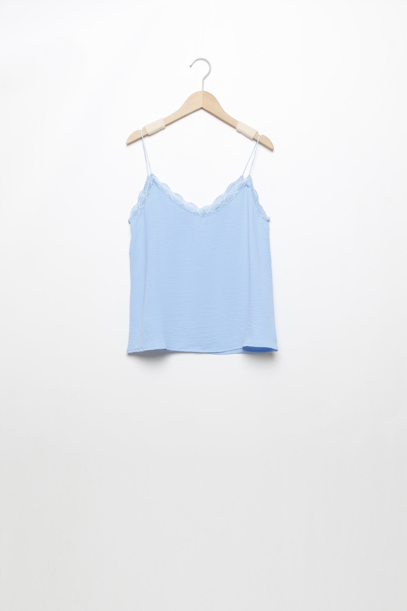 Top en mousseline femme fluide à bretelles avec dentelle bleue, en vue suspendue, style frais.