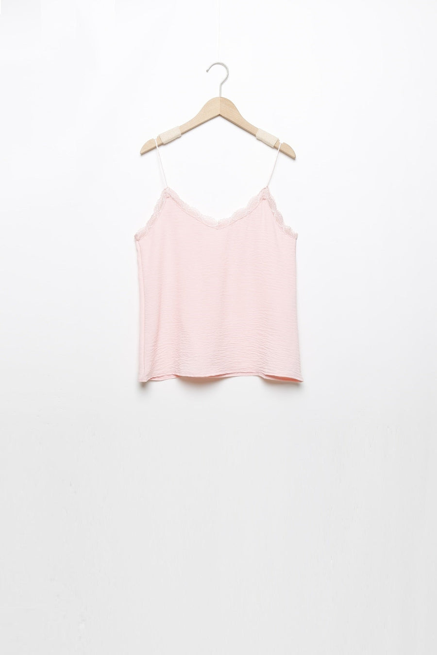 Top en mousseline femme fluide à bretelles avec dentelle rose, suspendu, prêt à être ajouté à la garde-robe.