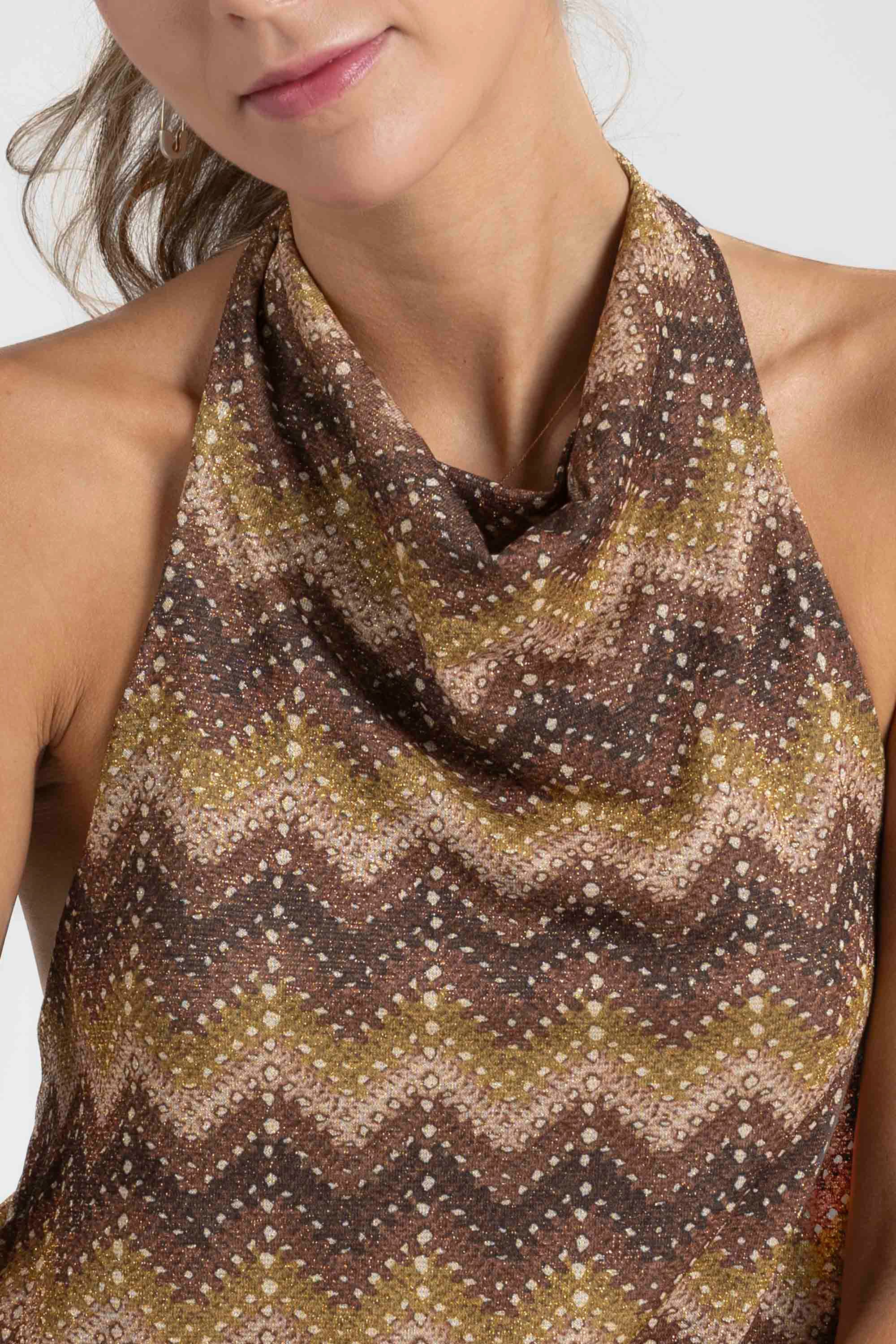 Gros plan sur le col du top halter imprimé femme, montrant le design élégant et les couleurs chaudes.