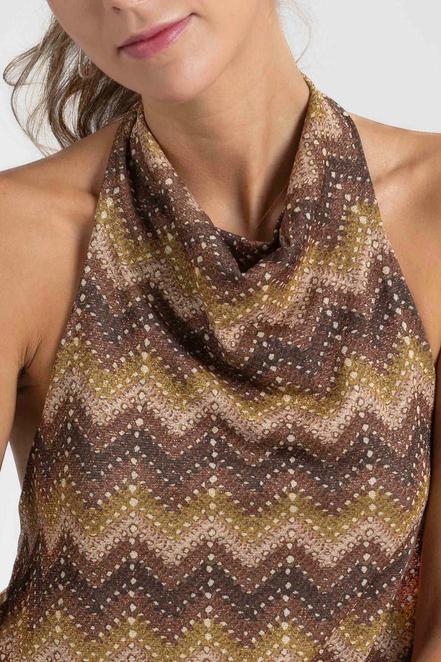Gros plan sur le col du top halter imprimé femme, montrant le design élégant et les couleurs chaudes.