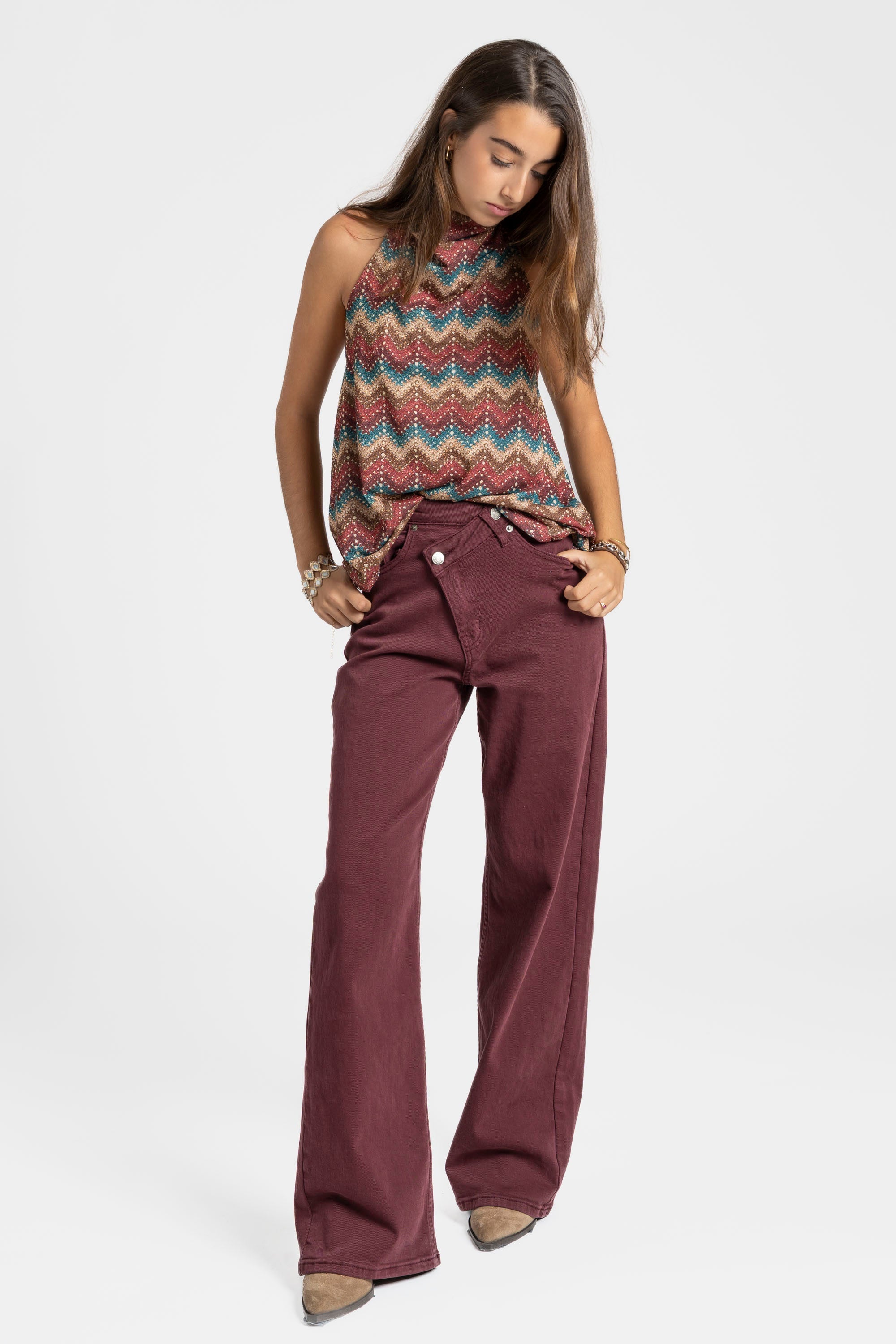 Modèle portant un top halter imprimé femme avec un pantalon bordeaux, pour un look sophistiqué.