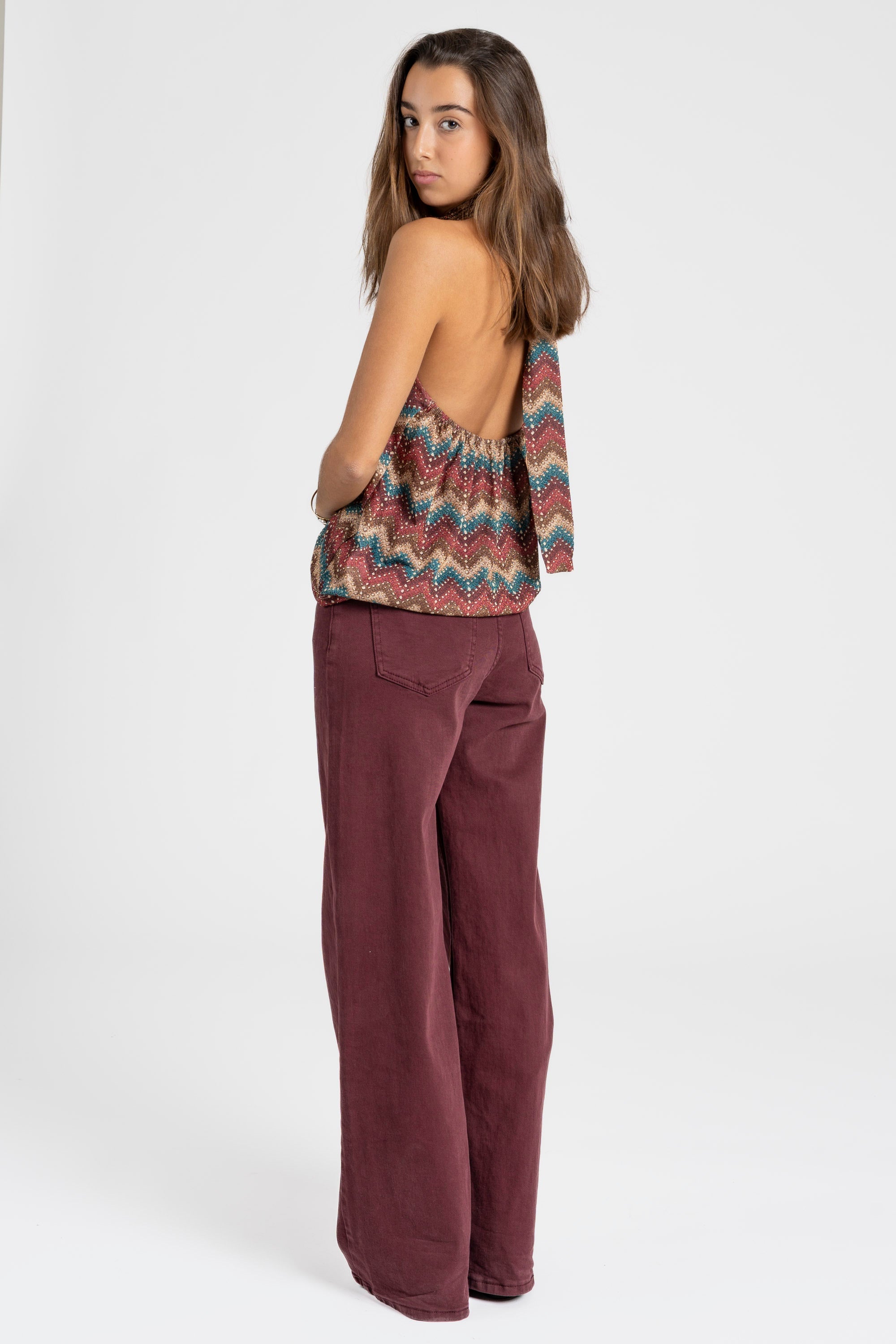 Vue arrière du top halter imprimé femme avec design coloré, montrant une silhouette décontractée.