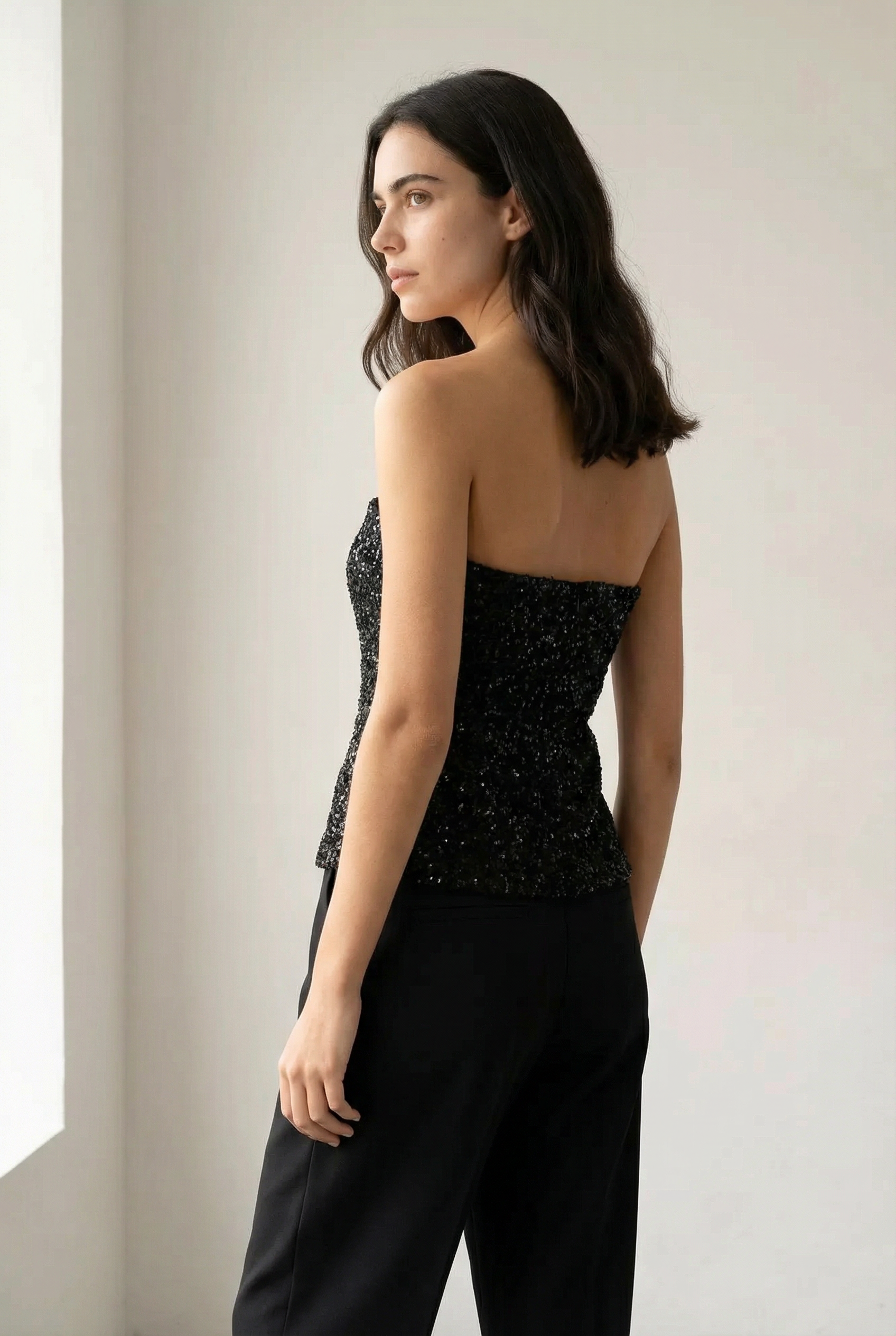 Elegante top de lentejuelas negro sin tirantes para mujer, perfecto para un look minimalista.
