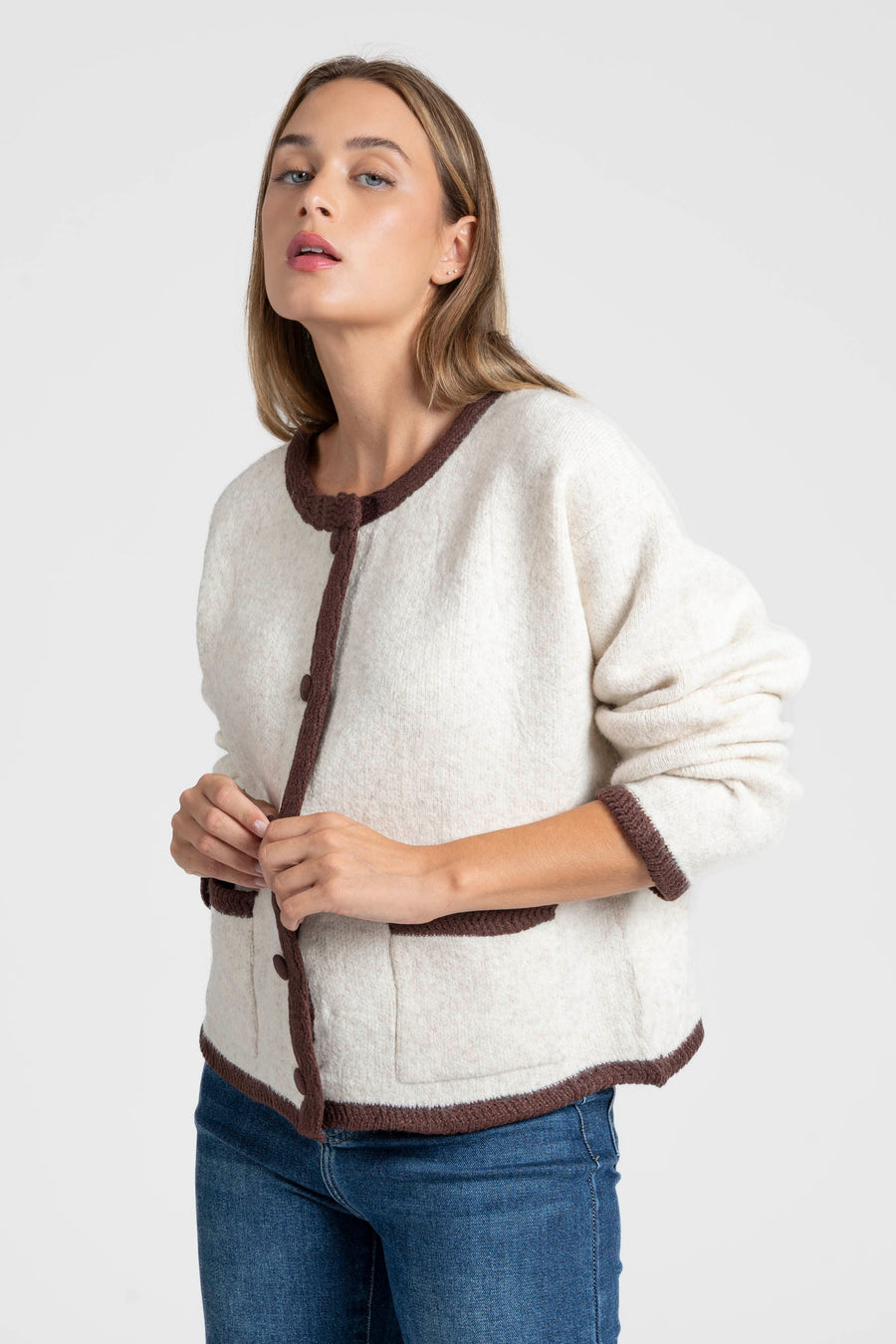 Veste en maille contrastée chic – Coupe droite – Beige ou gris – Maille laine mélangée, portée par une femme avec un look élégant.