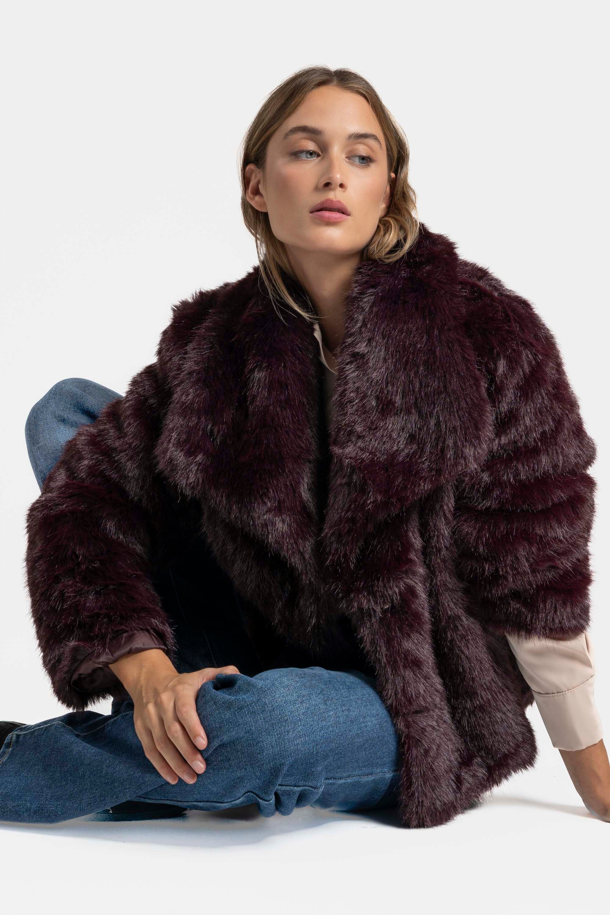 Femme dans une Veste fausse fourrure bordeaux, offrant une esthétique automnale séduisante avec un look décontracté.