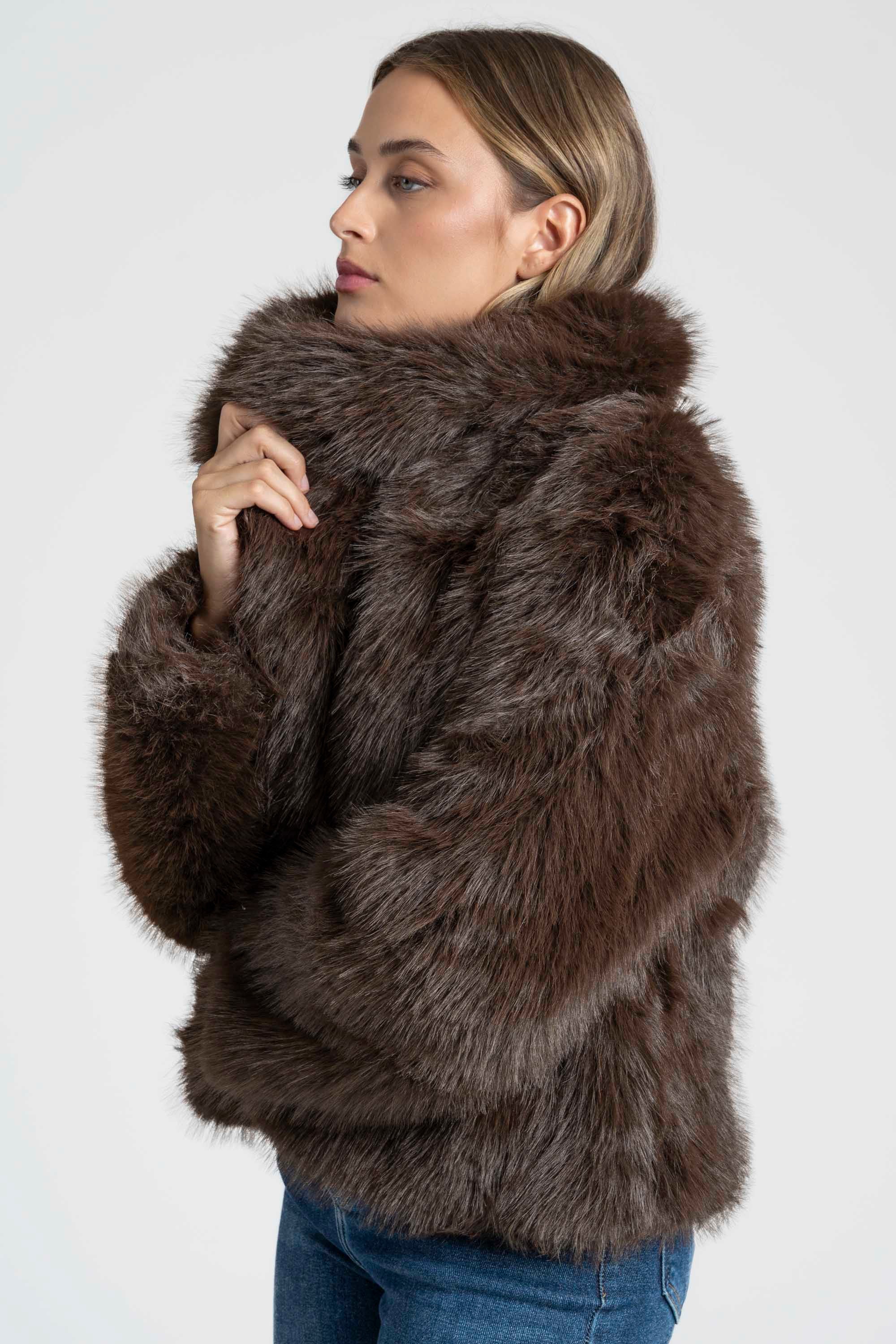 Modèle portant une Veste fausse fourrure marron, robe en fourrure douce avec un col large, parfaite pour un look décontracté.