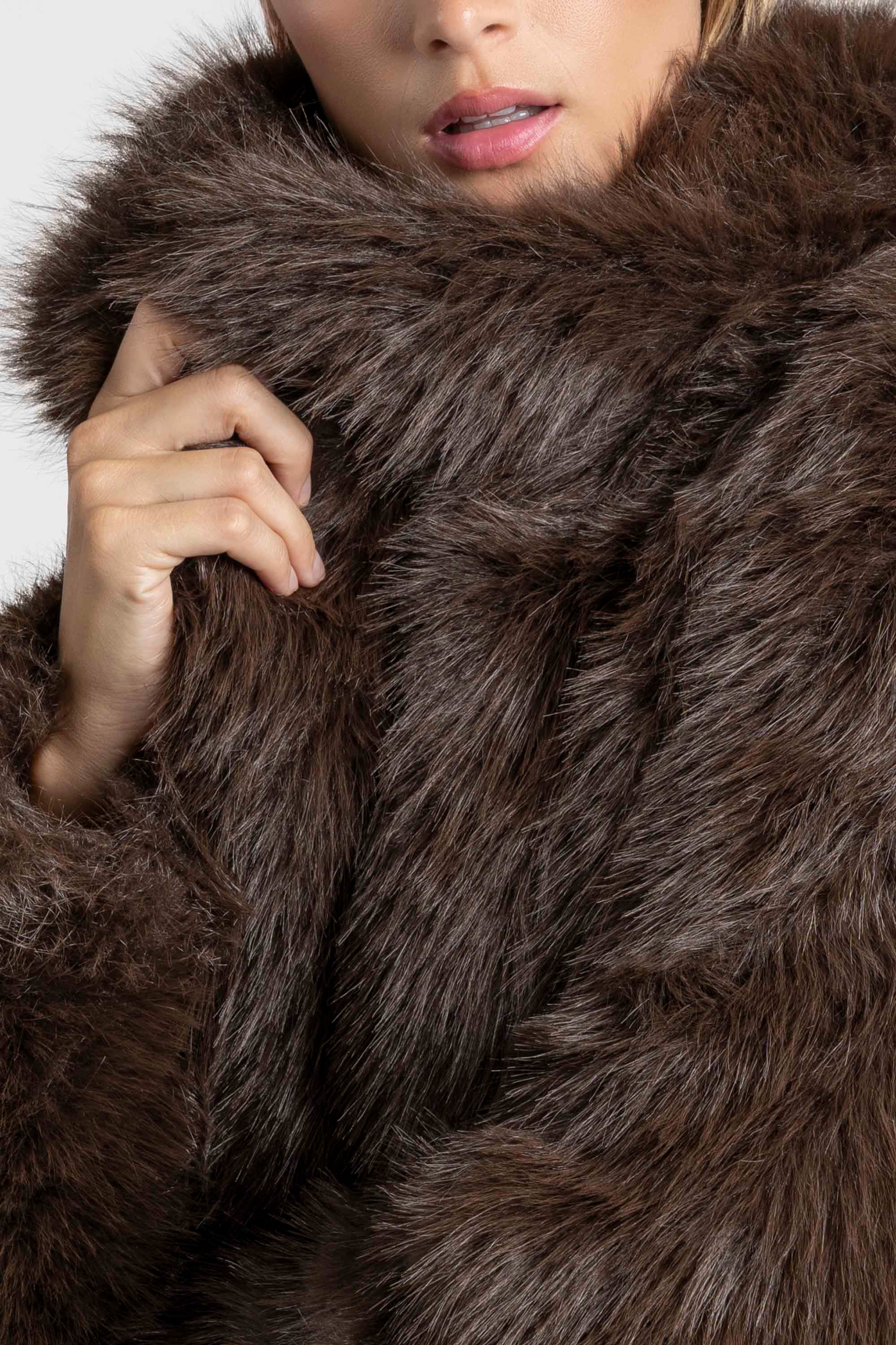 Gros plan sur une Veste fausse fourrure marron, mettant en valeur la texture douce et le col haut.