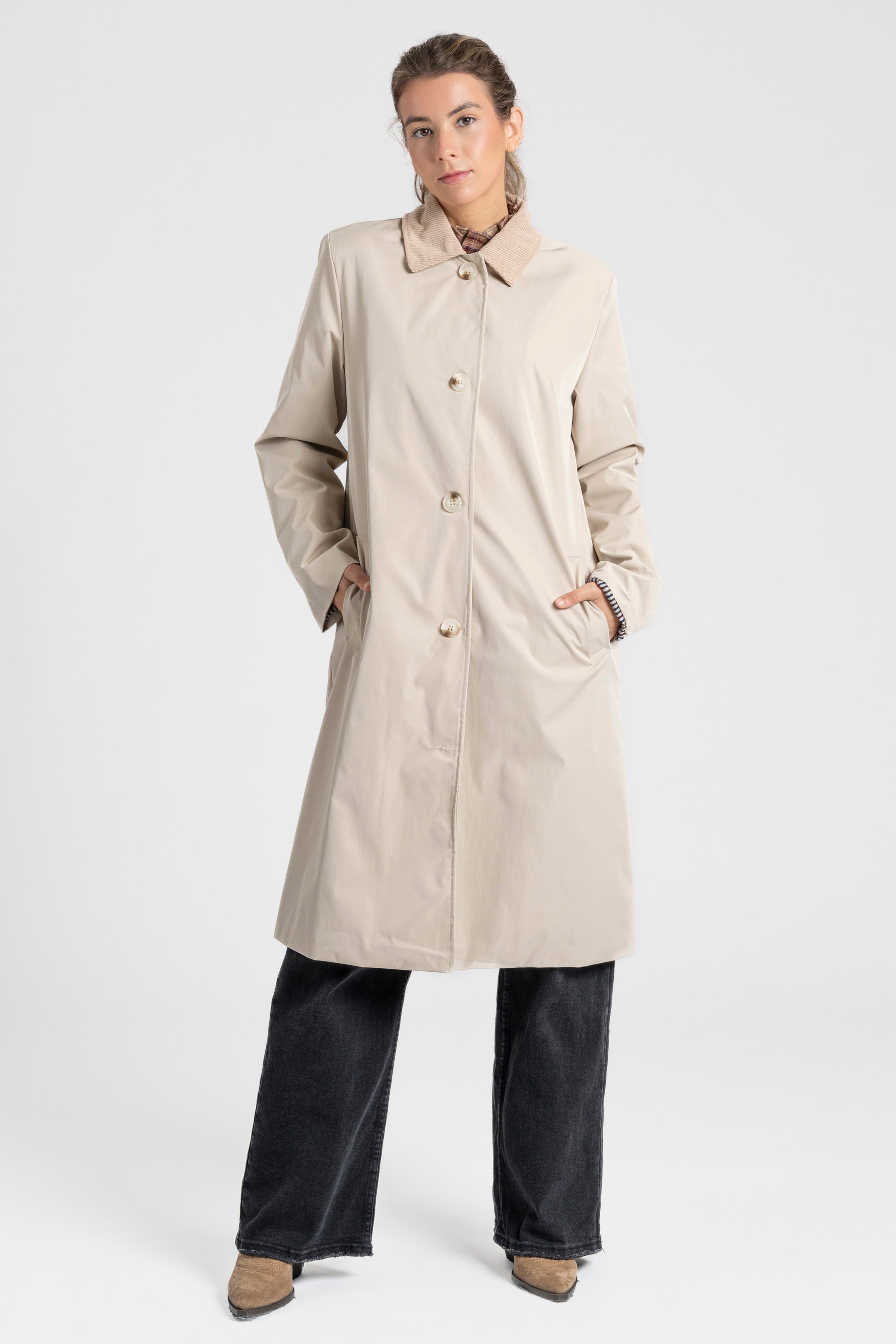 Femme moderne en Veste imperméable Coupe droite Col velours de couleur crème, posant avec confiance.