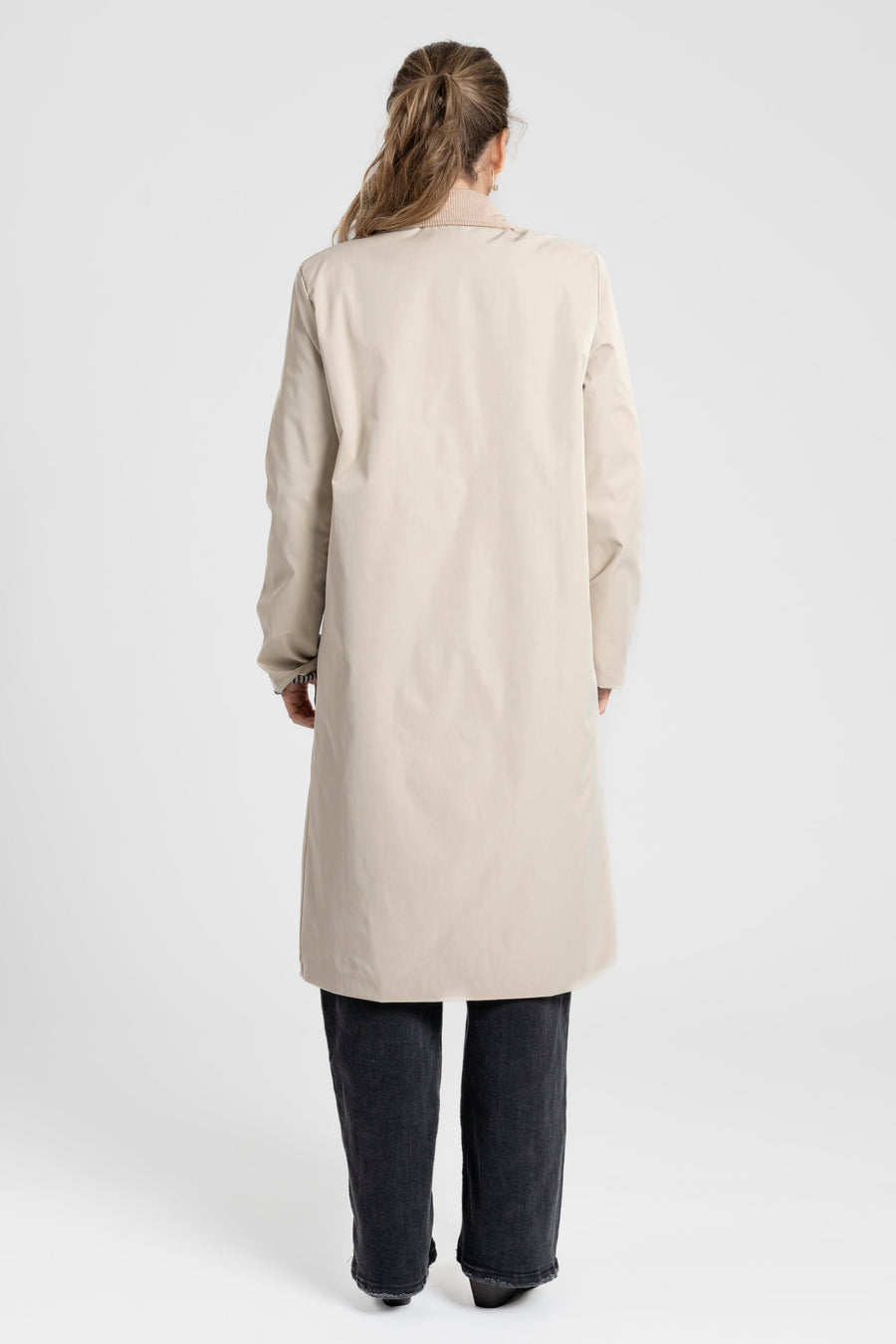 Vue arrière mettant en valeur la silhouette d'une femme avec une Veste imperméable Coupe droite Col velours.