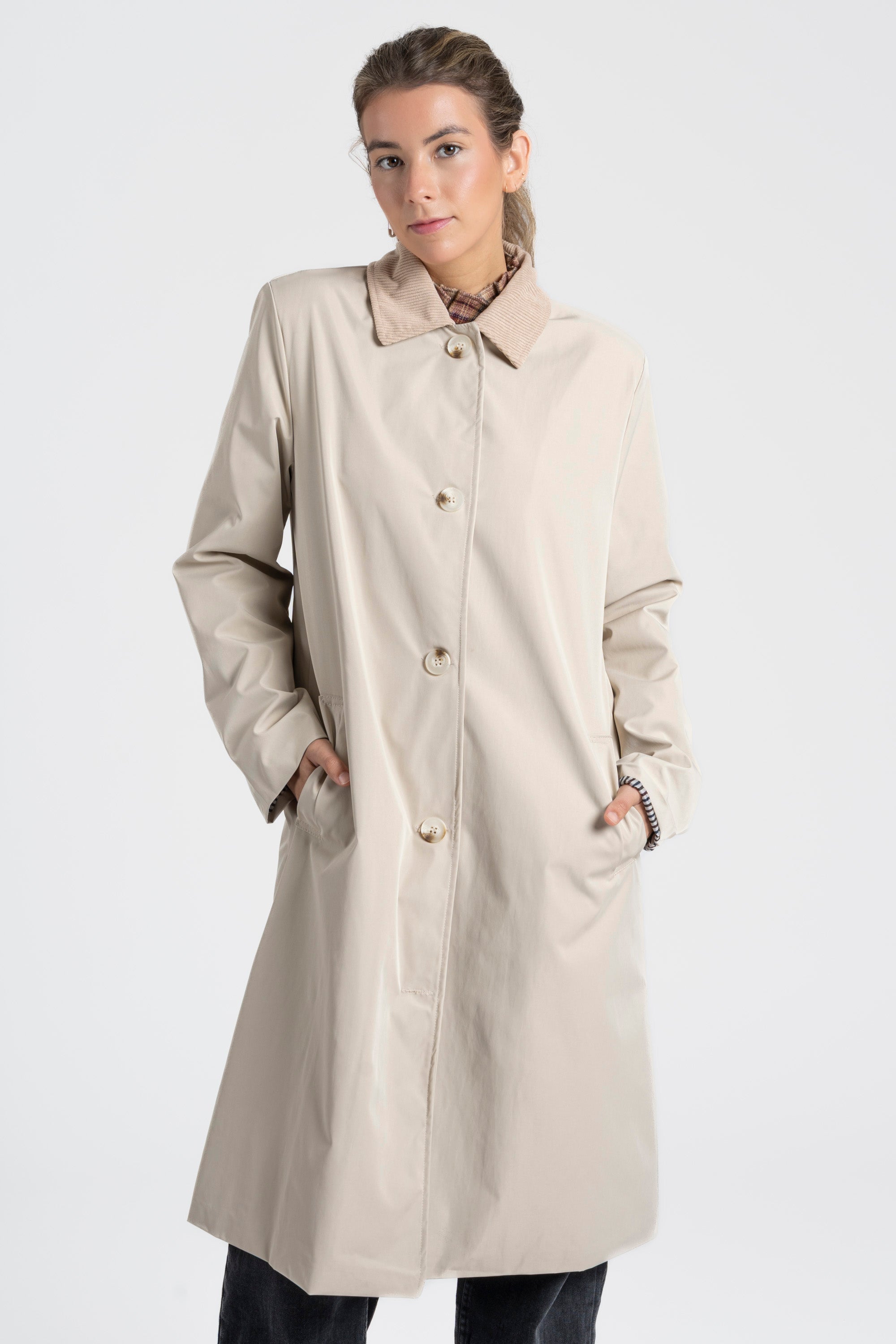 Femme en Veste imperméable Coupe droite Col velours, mains dans les poches, apportant une touche décontractée.