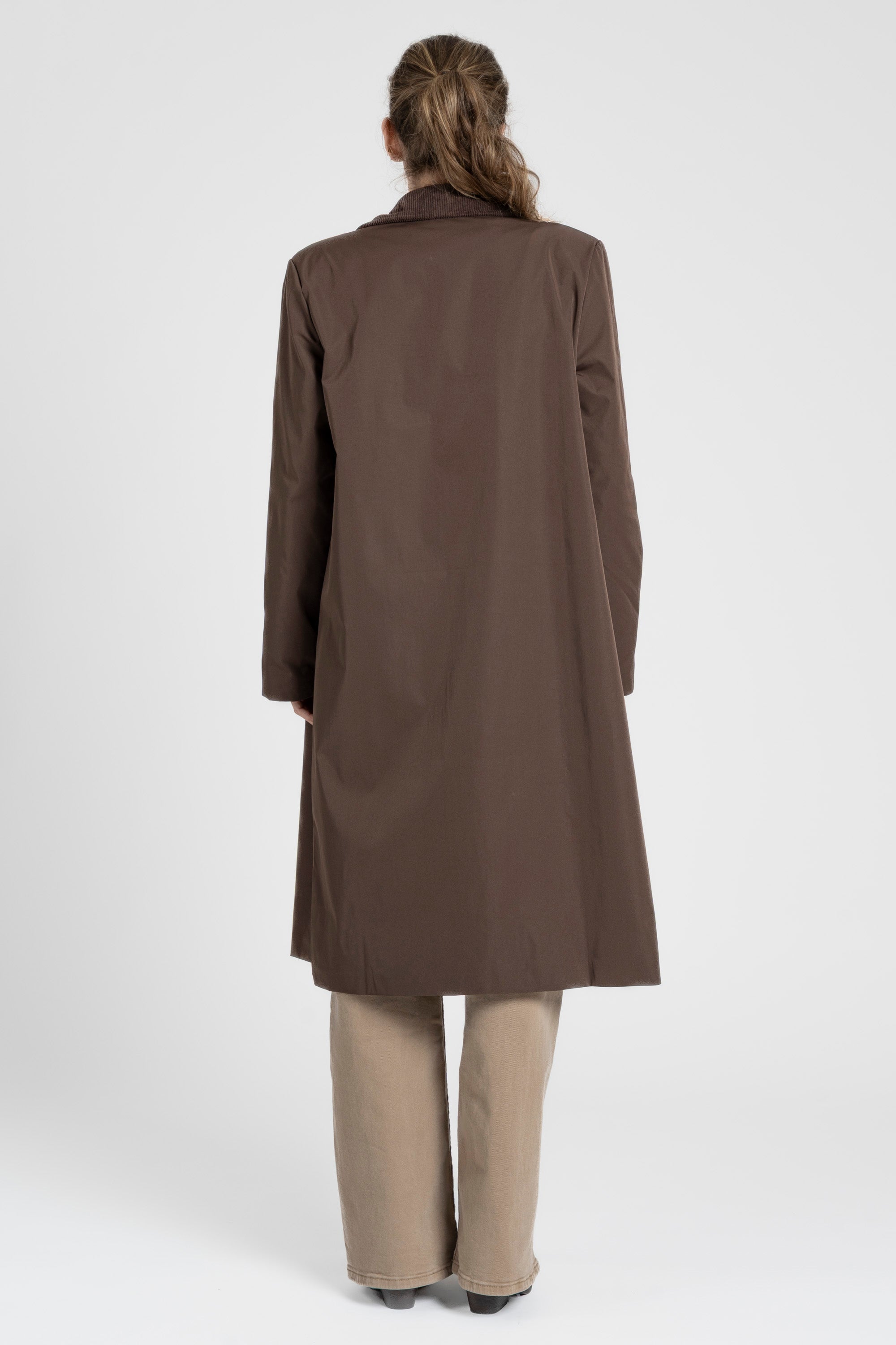 Vue arrière d'une femme avec une Veste imperméable Coupe droite Col velours, affichant la coupe et le style.