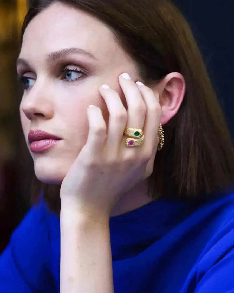 Une femme élégante portant la Bague Serpent Élégante en Or Avec Pierres Précieuses de Sapiato, mettant en valeur le bijou unique 'bague serpent' avec des pierres scintillantes.