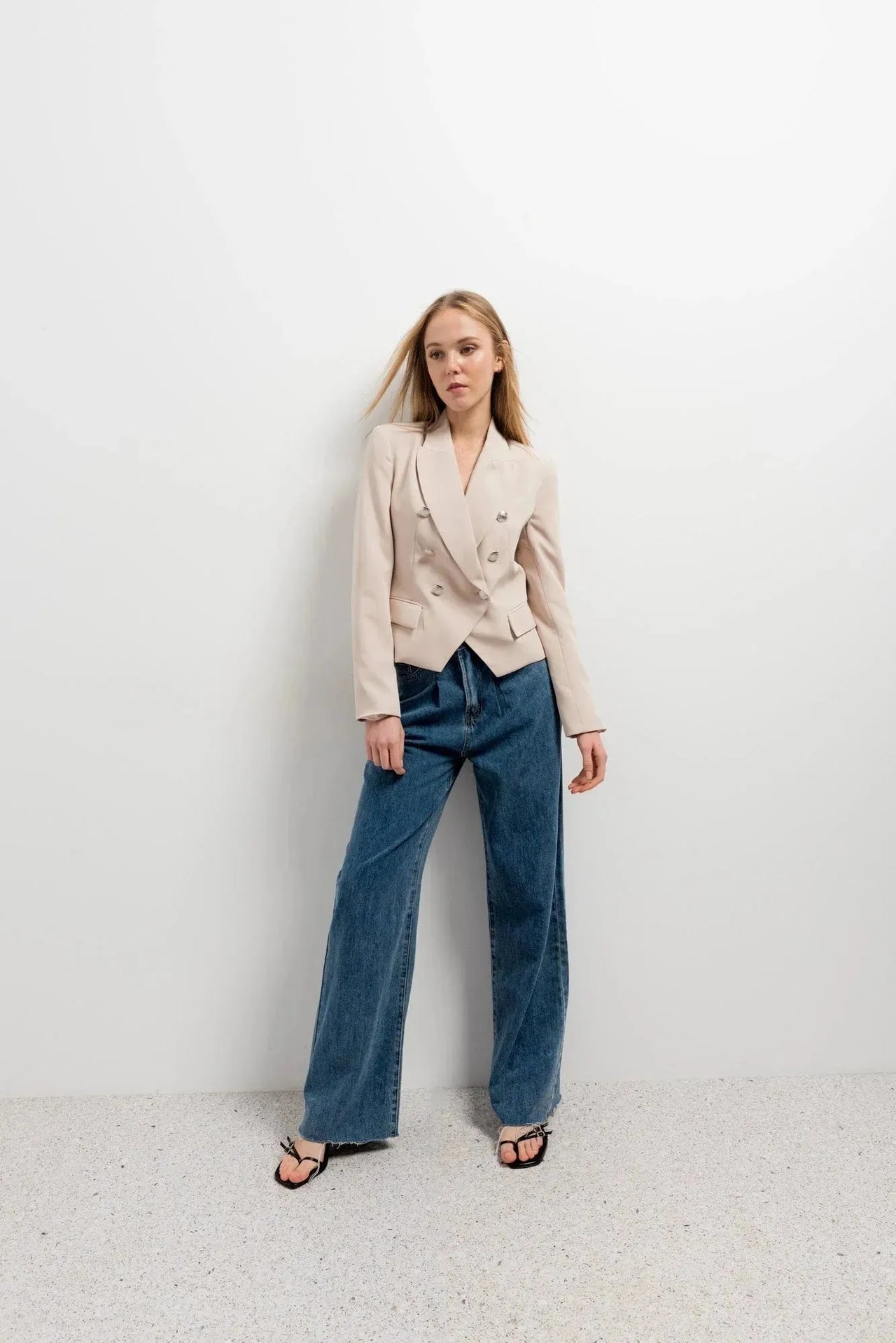 Blazer boutonné à double poitrine pour femme en beige avec peaking lapels et jeans bleus