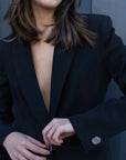 Détails du Blazer Femme Noir à Boutons Argentés, avec un modèle ajustant la boutonnière, soulignant la sophistication de ce blazer chic femme.